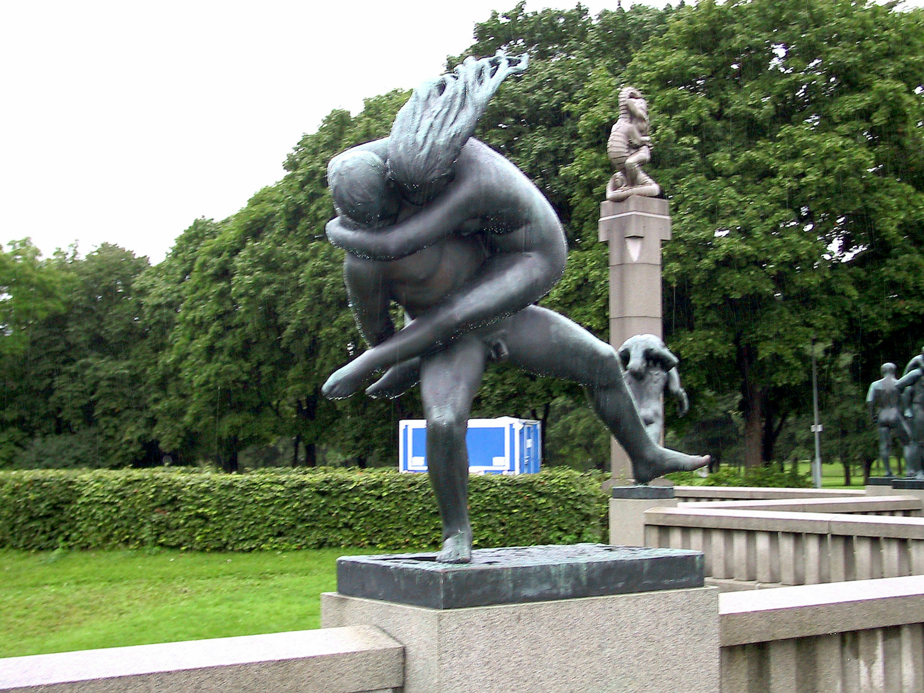 Una scultura in bronzo di un ballerino in una posa appassionata situata in un parco