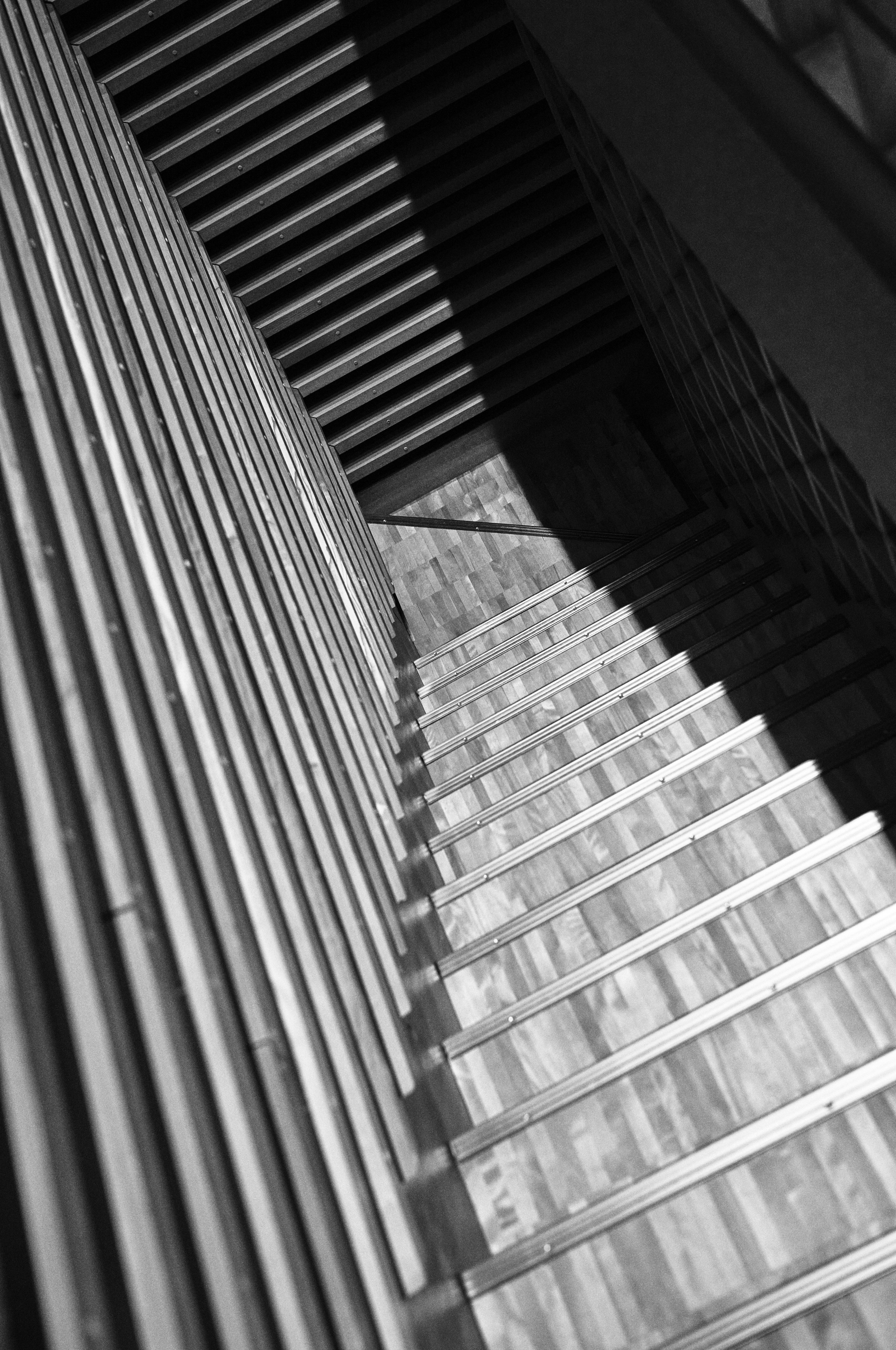 Blick von oben auf eine Treppe mit Metallgeländer und Holzstufen