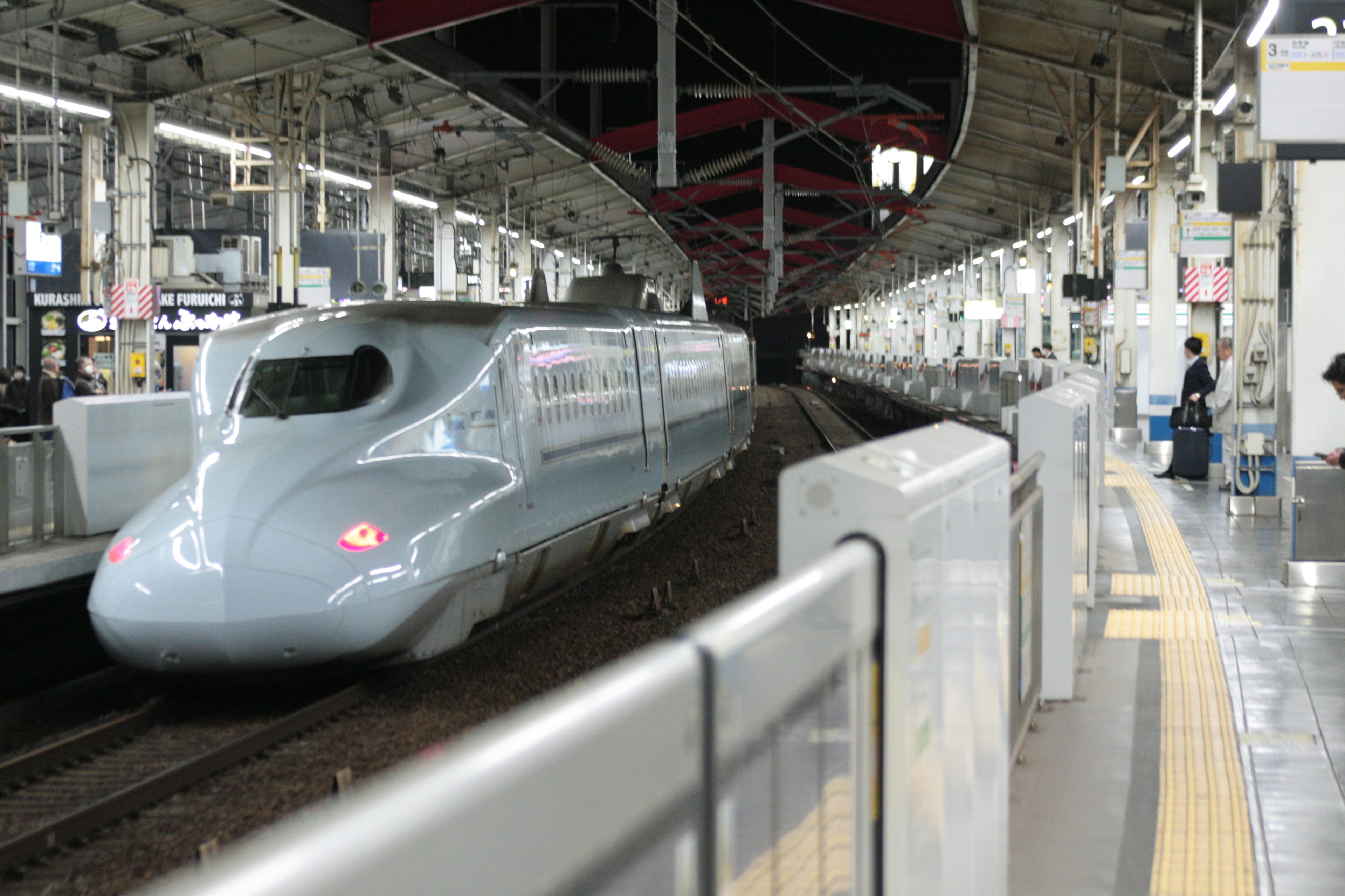 Shinkansen, der an einem Bahnhof ankommt mit sichtbarem Bahnsteig