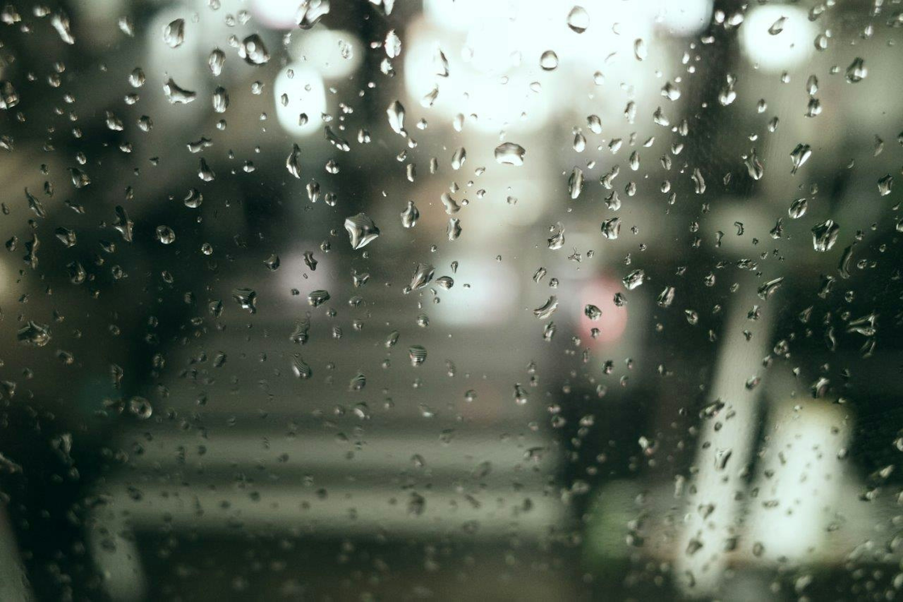 雨に濡れた窓越しの街の風景