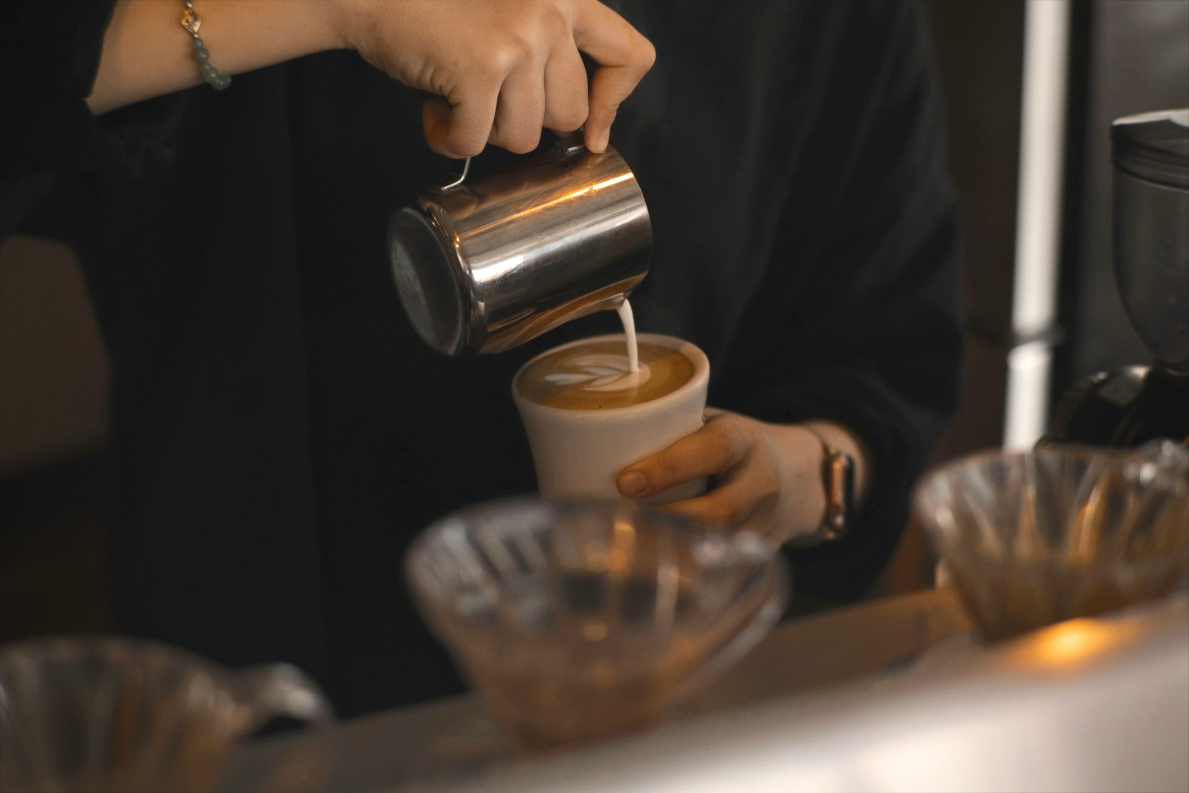 Barista gießt Kaffee in eine Tasse