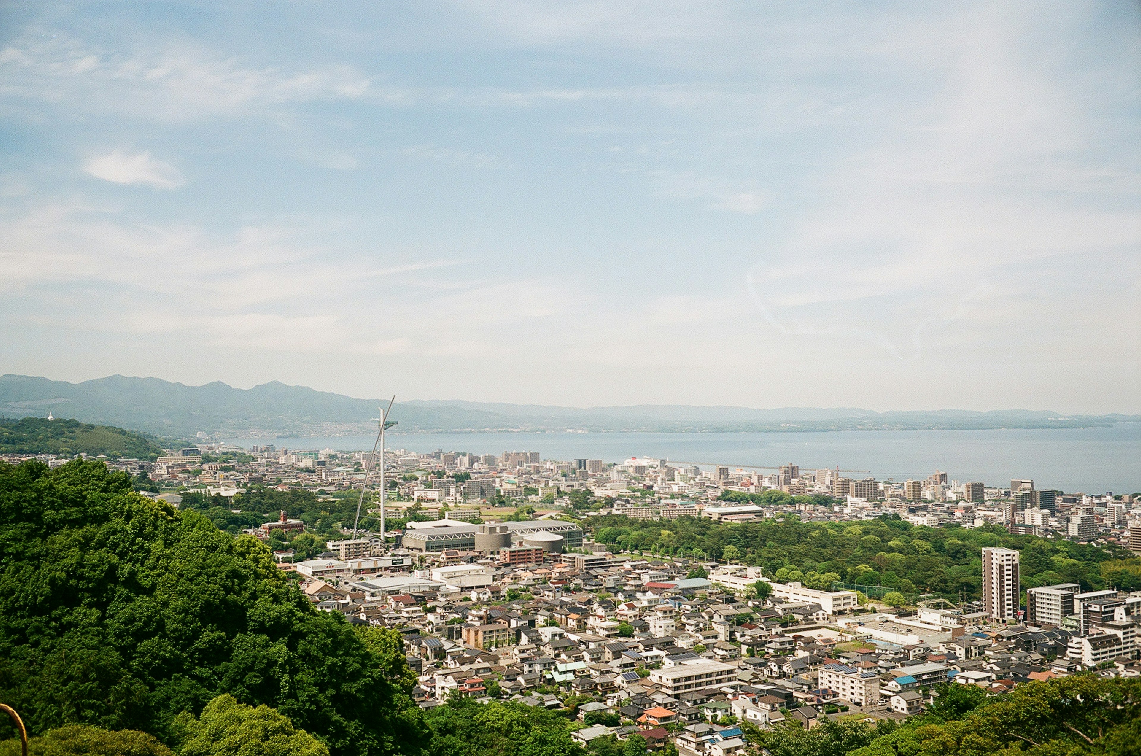 Panoramablick auf eine Stadt, umgeben von Bergen und dem Meer