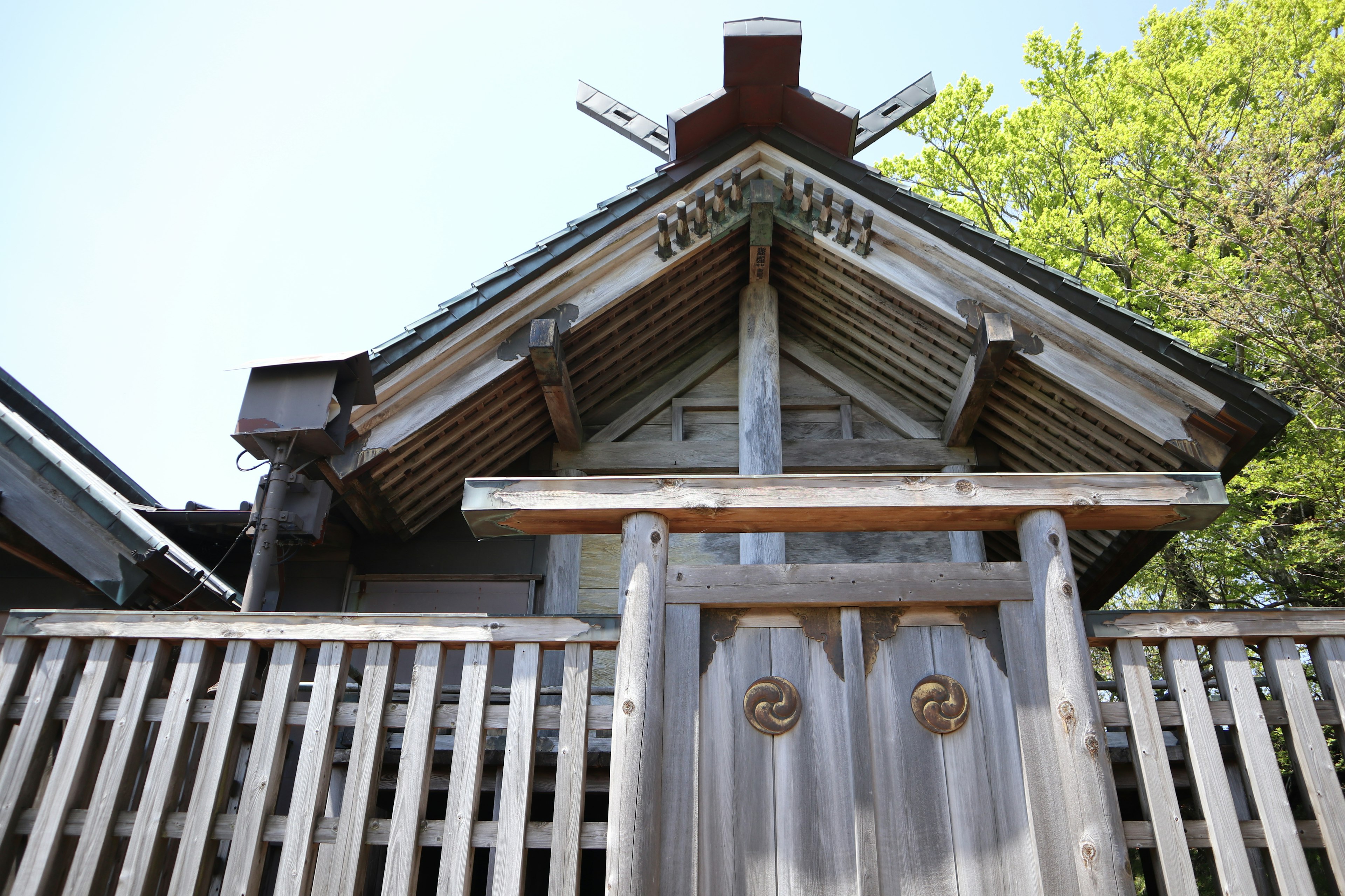 古い神社の入り口の木製の扉と屋根の装飾