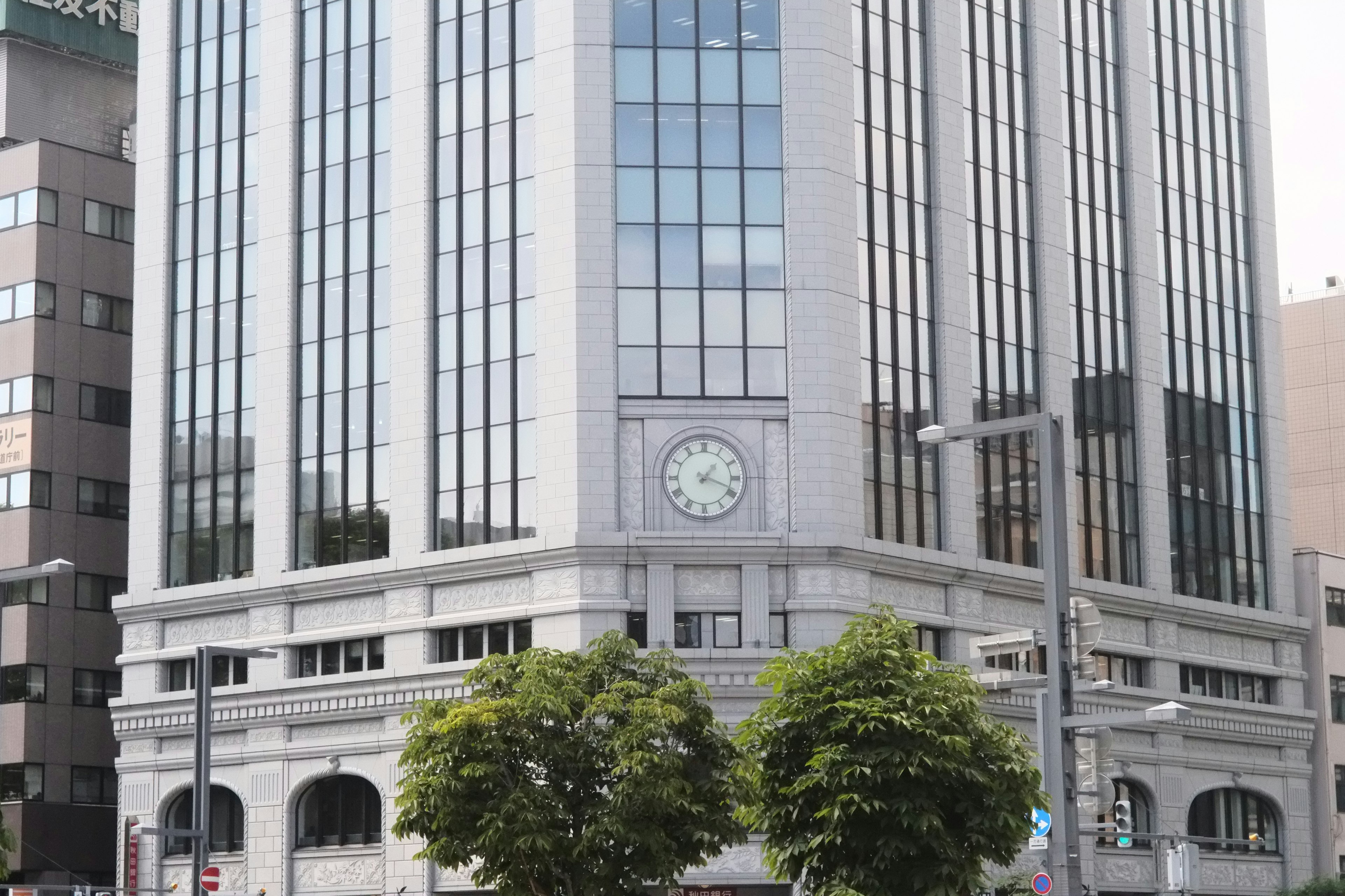 Extérieur d'un bâtiment de bureaux moderne avec une façade en verre et un design de pendule classique