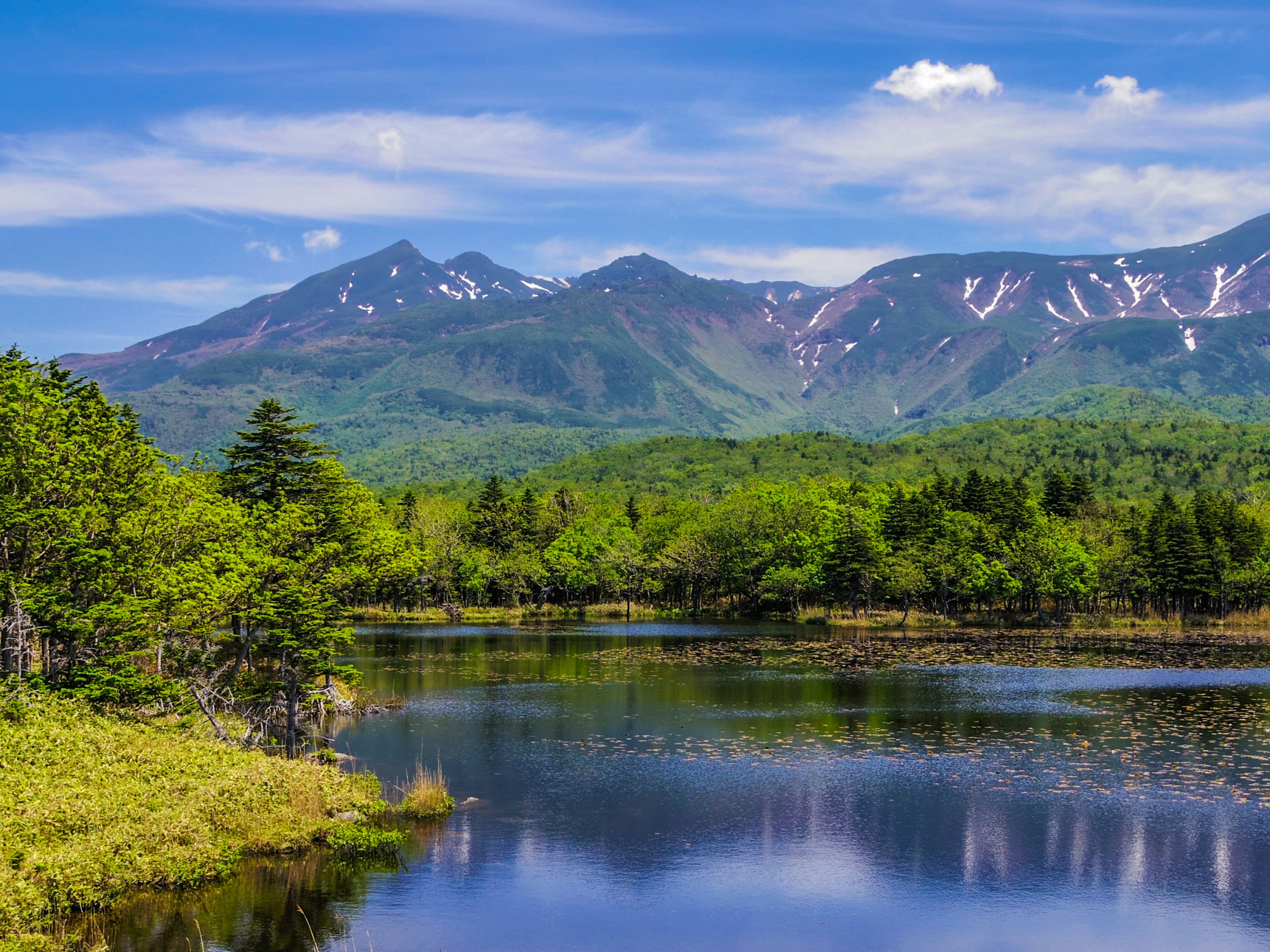 宁静湖泊周围环绕着山脉和郁郁葱葱的森林的风景