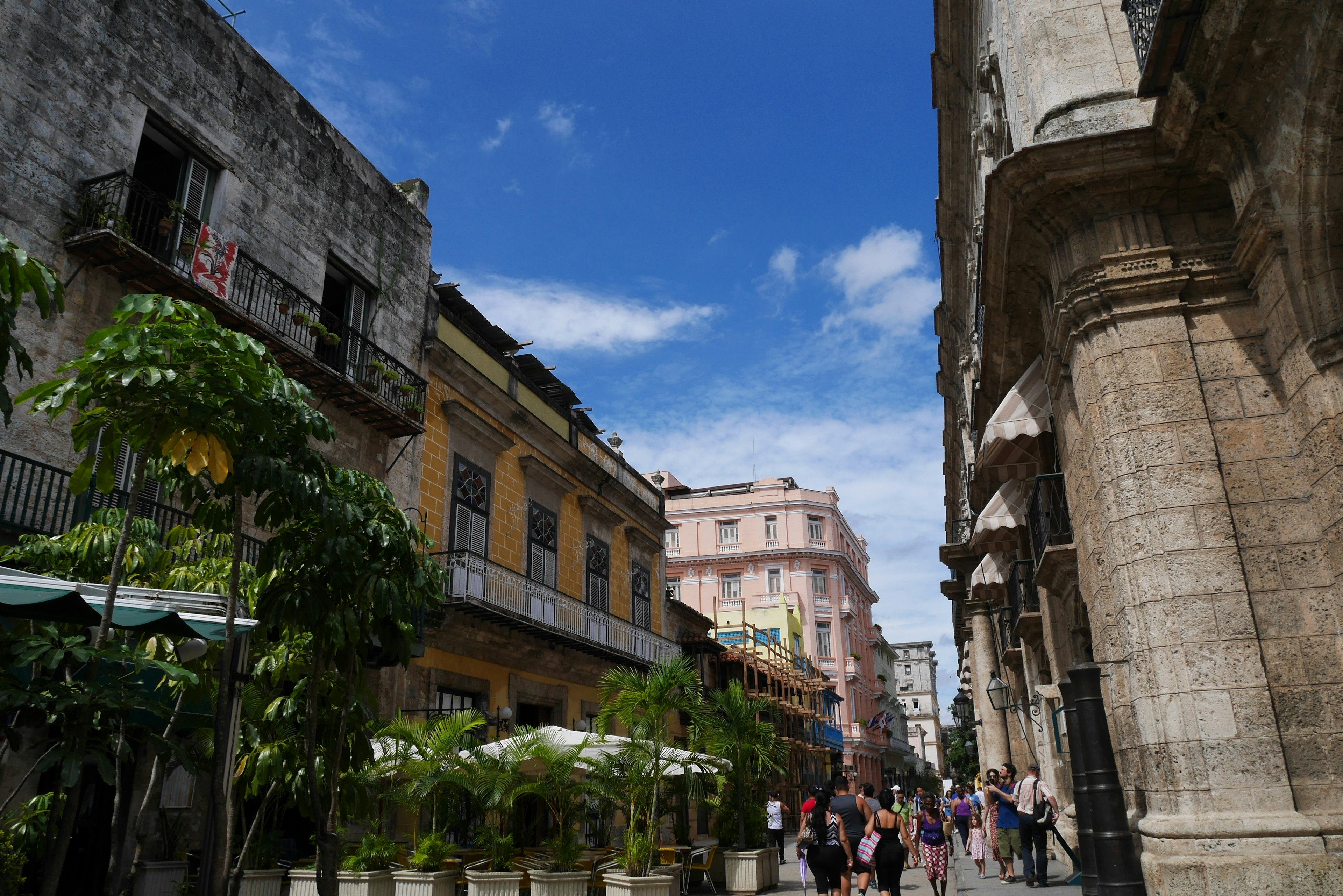 Vista di strada con edifici colorati e persone che camminano sotto un cielo blu