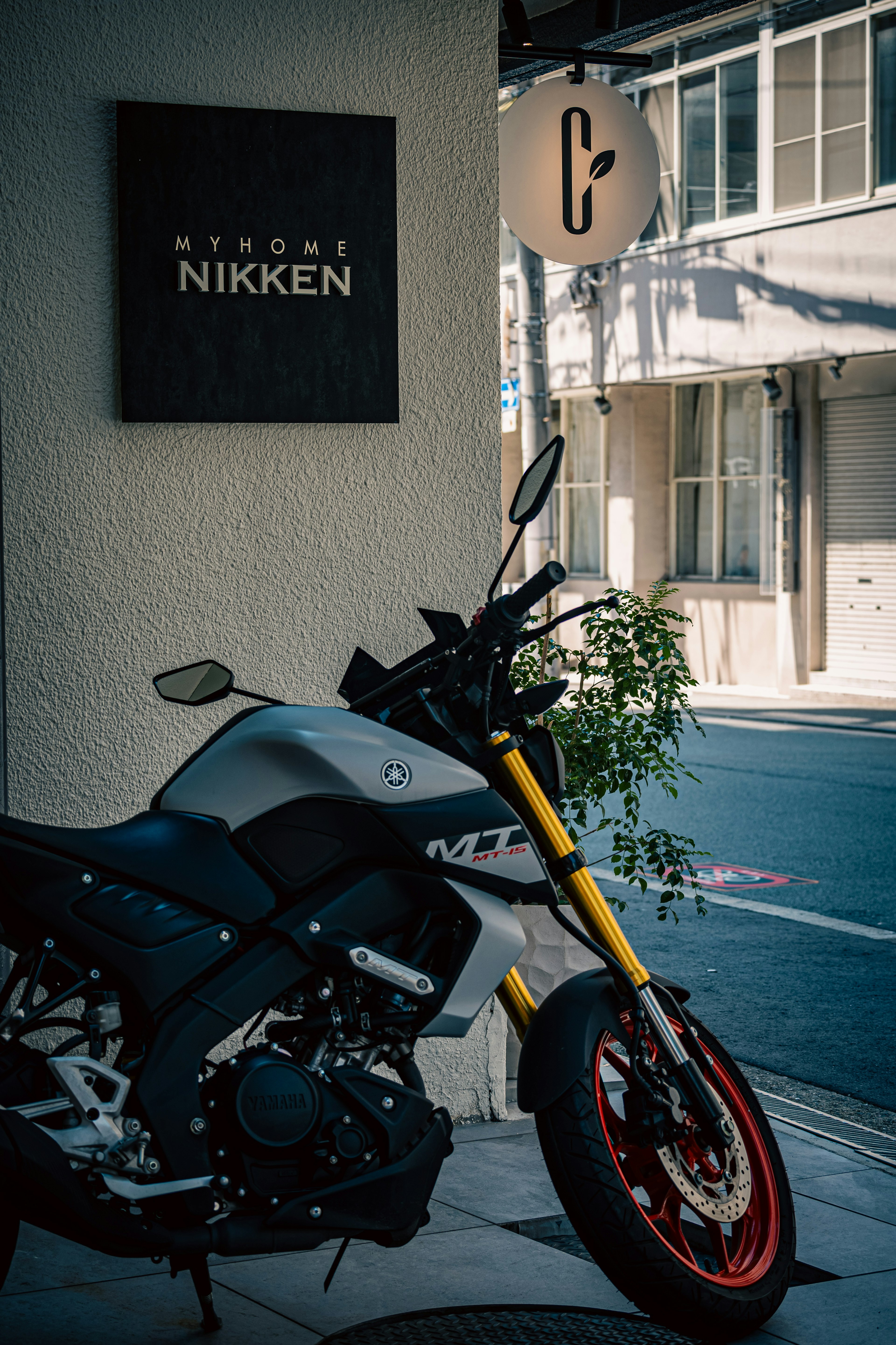 Moto deportiva estacionada frente al cartel de Nikken