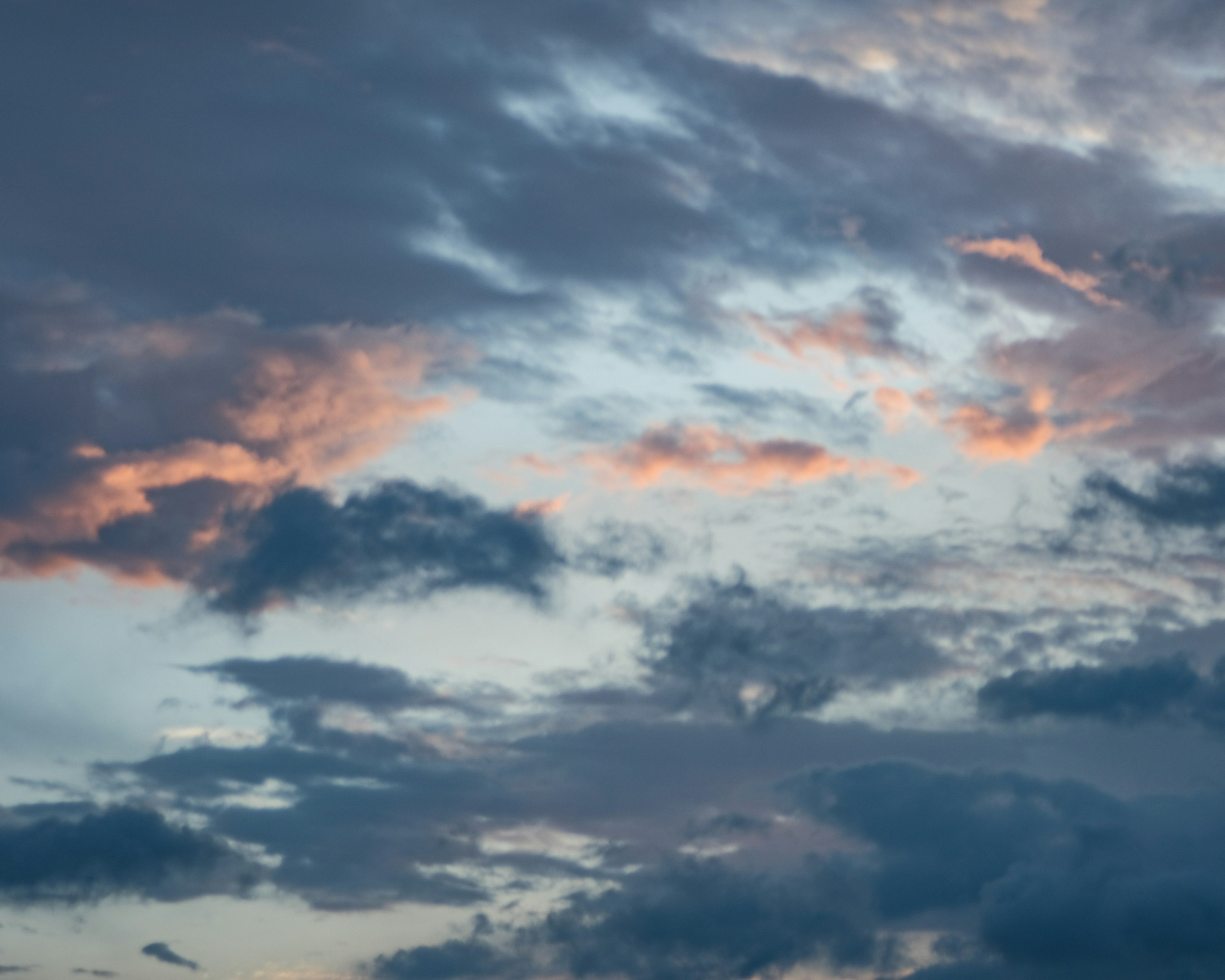 青い空にピンクとオレンジの雲が広がる美しい夕焼け