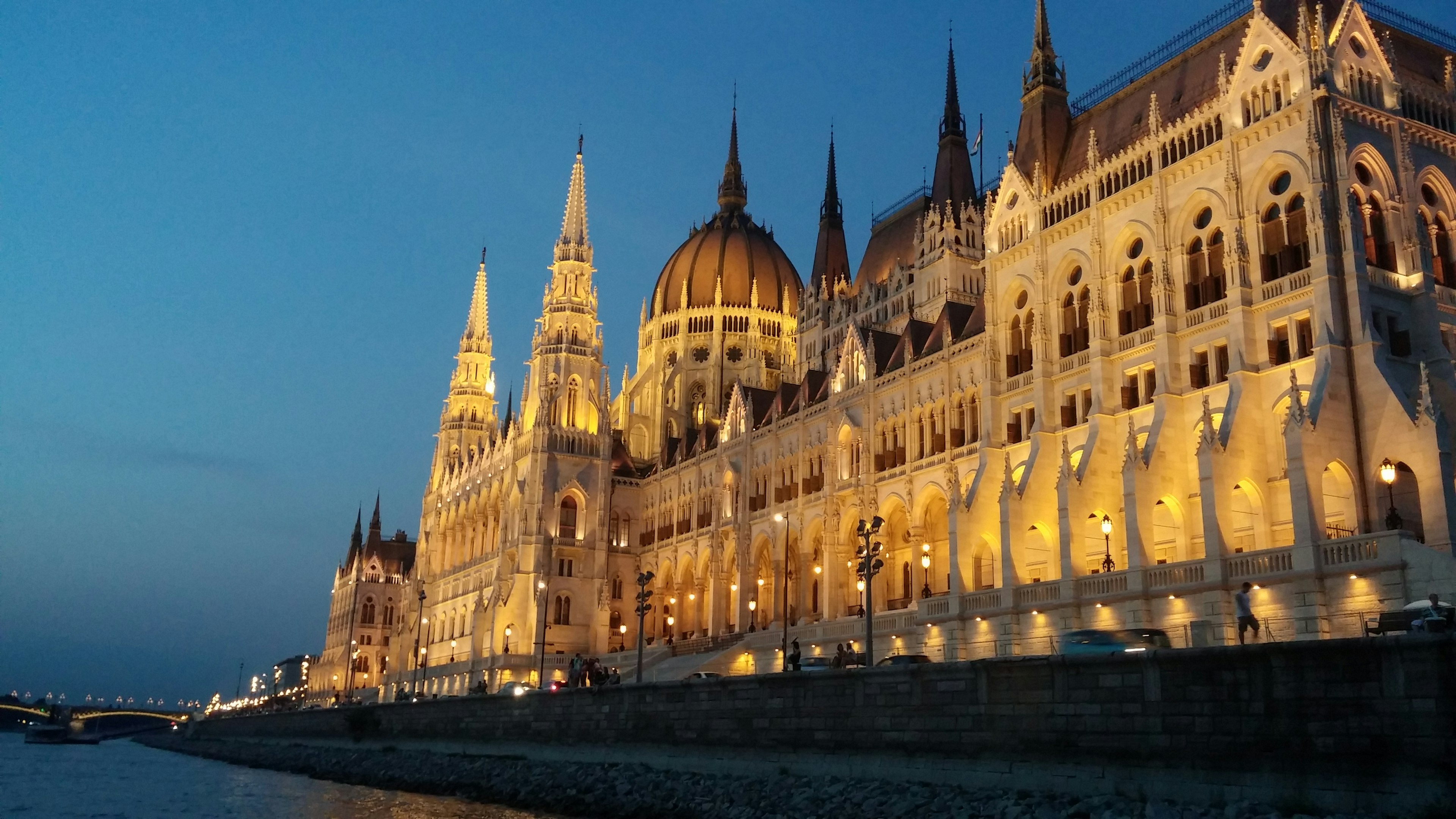 Night view of the Hungarian Parliament Building illuminated against a dark blue sky