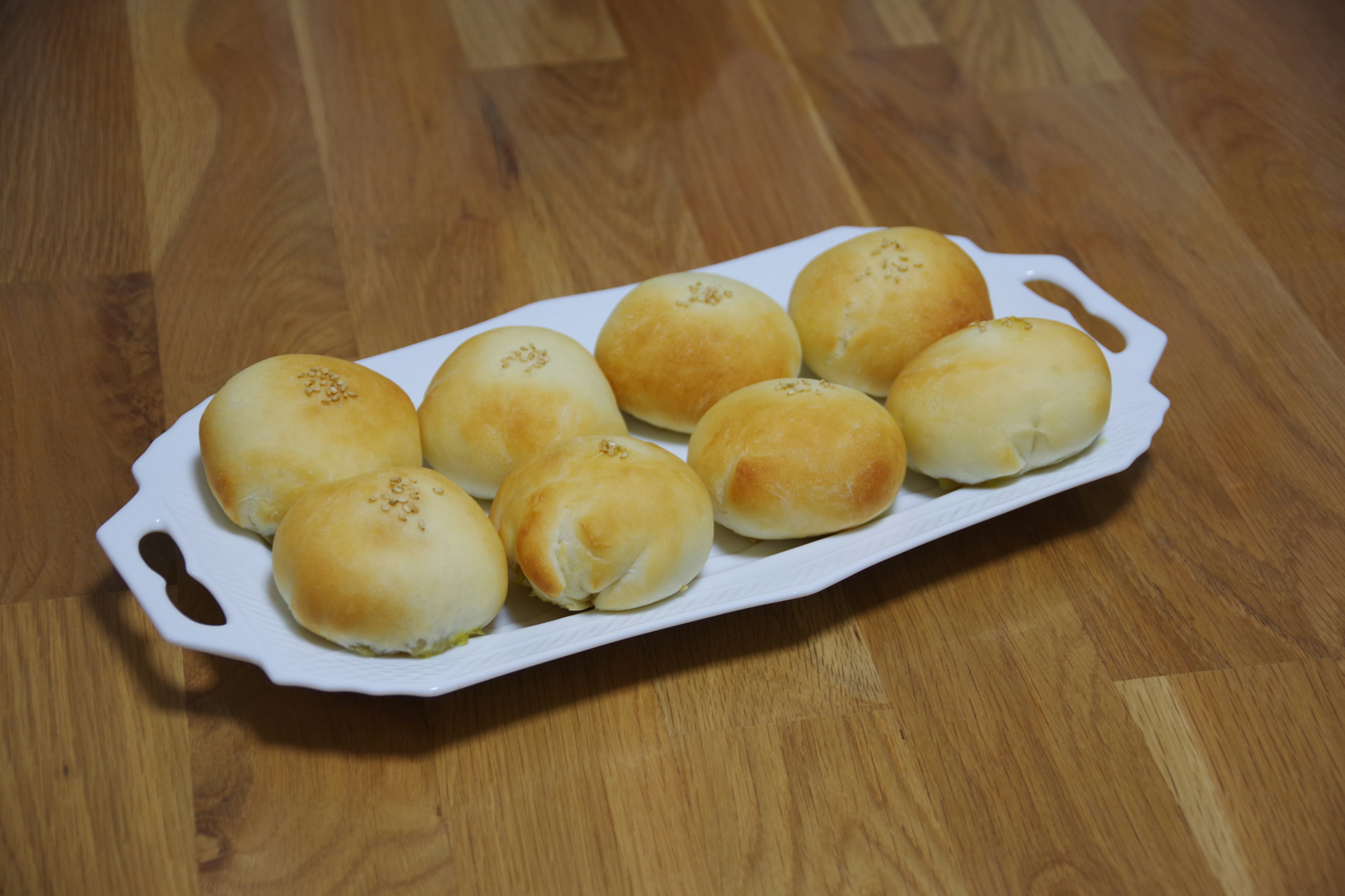 Freshly baked bread rolls arranged on a white platter