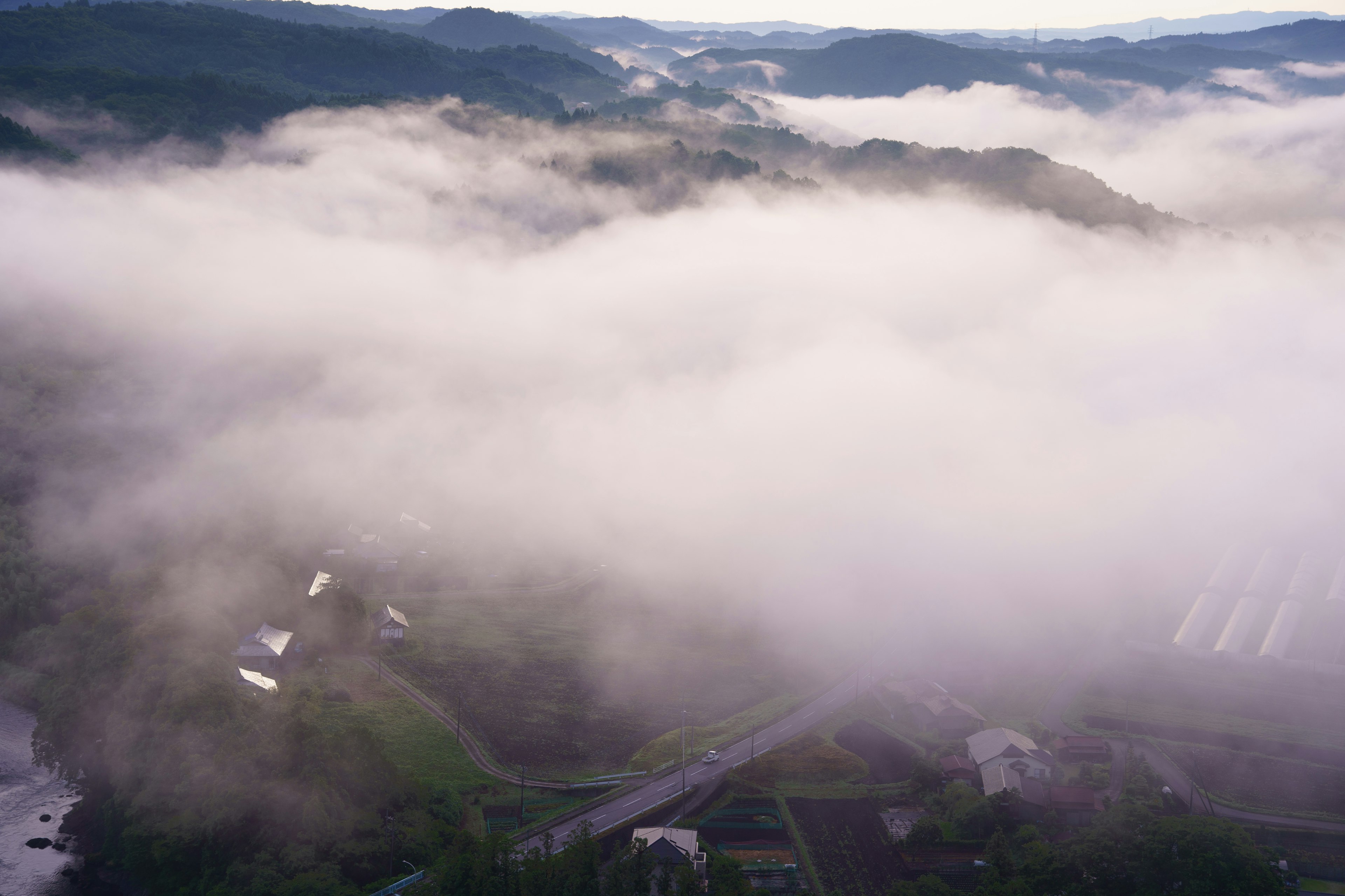 Vista aérea de montañas brumosas y granjas