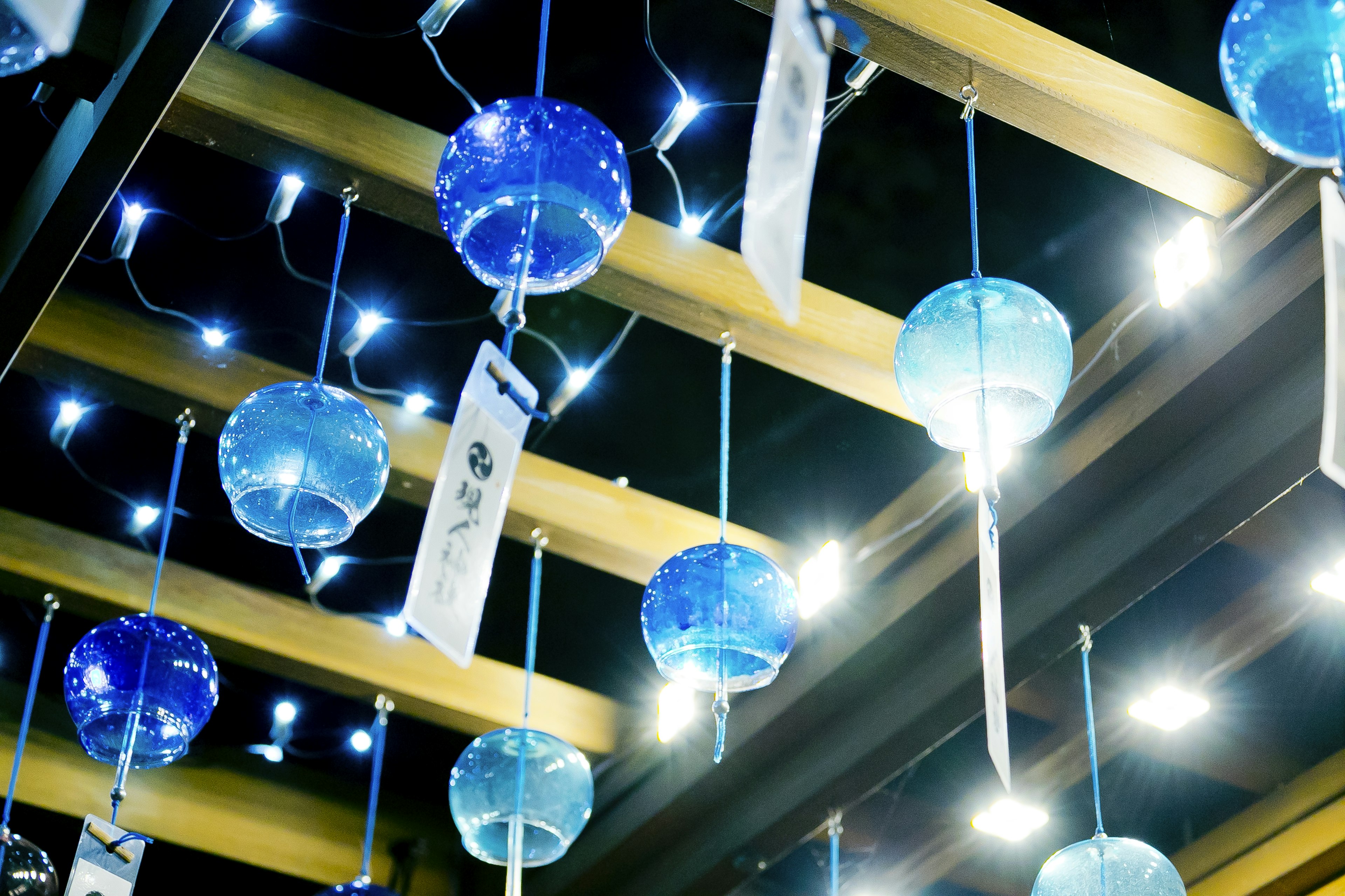 Decorative ceiling with hanging blue glass orbs illuminated by bright LED lights