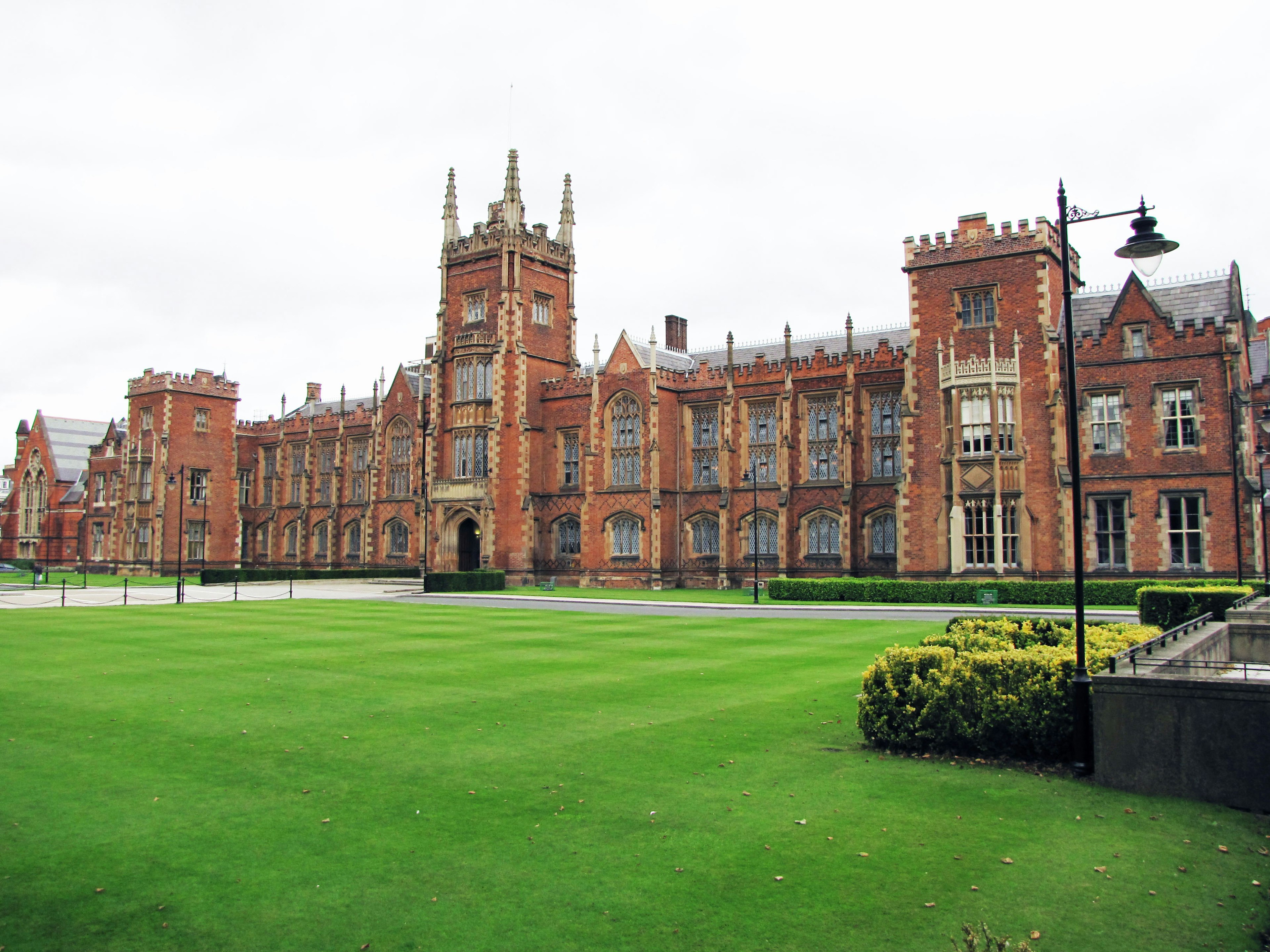 A beautiful brick building with expansive green lawn in a university campus