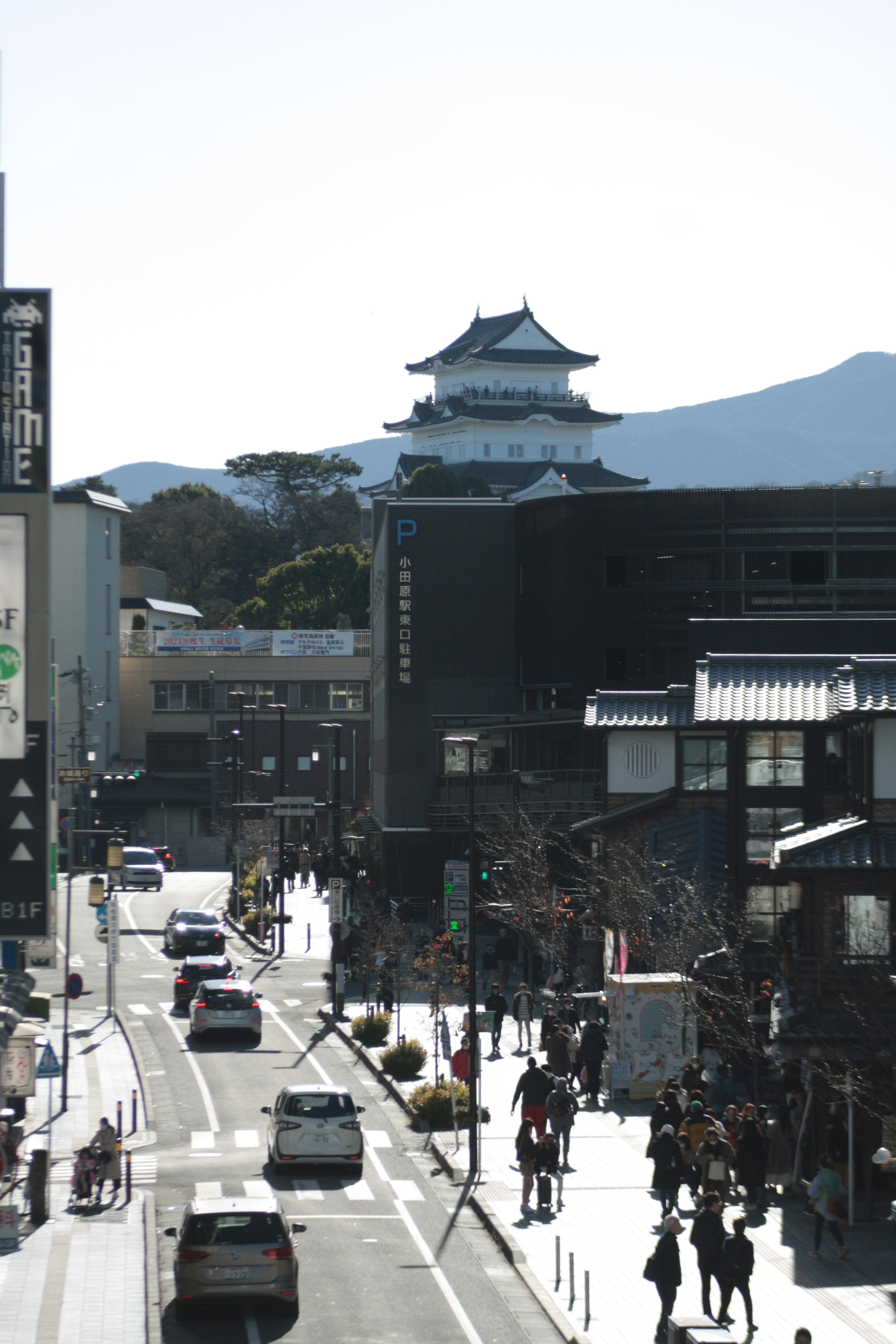 A busy street featuring a traditional castle and modern buildings