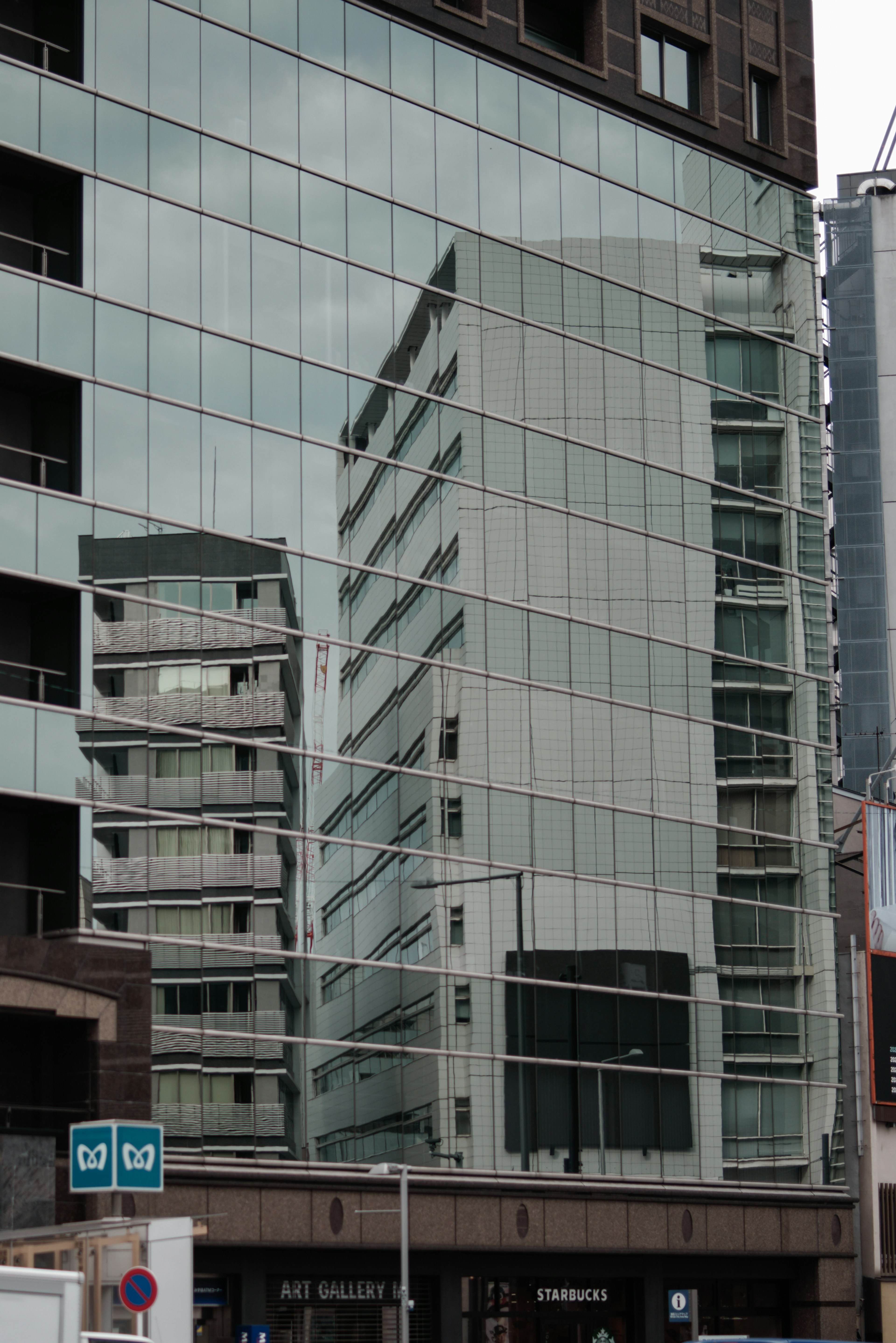 Reflejo de edificios en una fachada de vidrio que muestra la arquitectura urbana