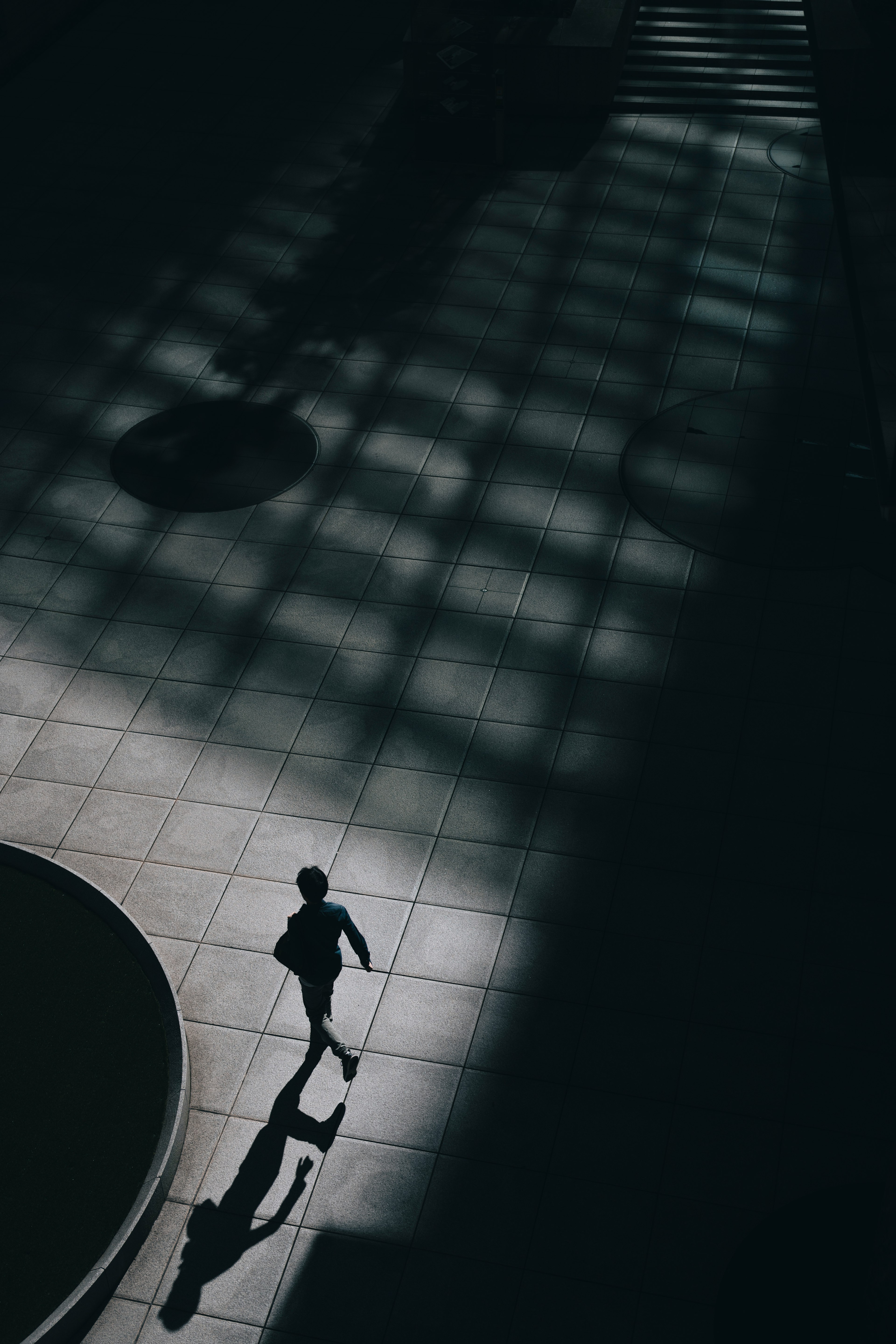 Silhouette d'une personne marchant dans l'ombre avec des motifs de lumière géométriques