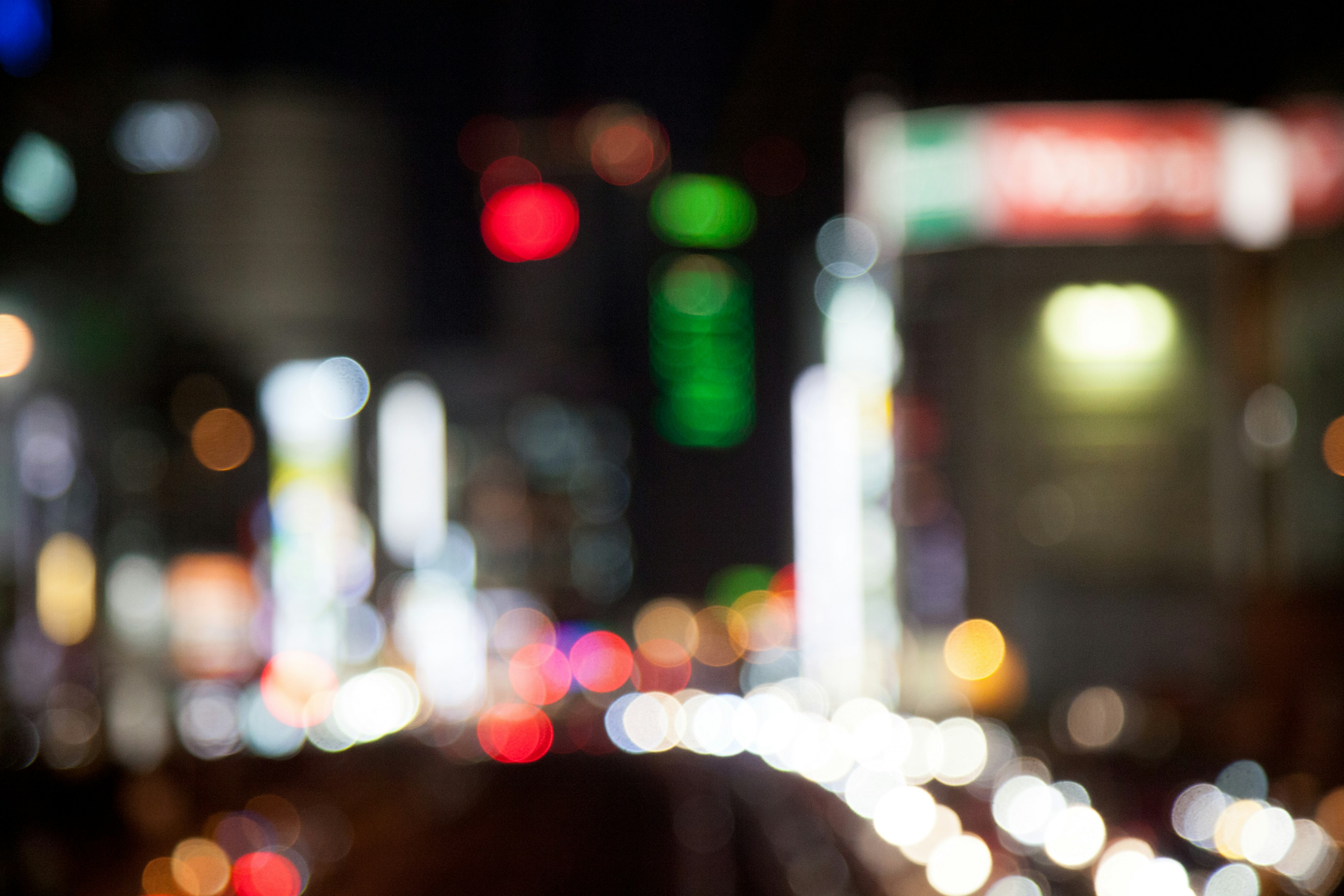 Immagine sfocata di un paesaggio urbano notturno con luci al neon colorate