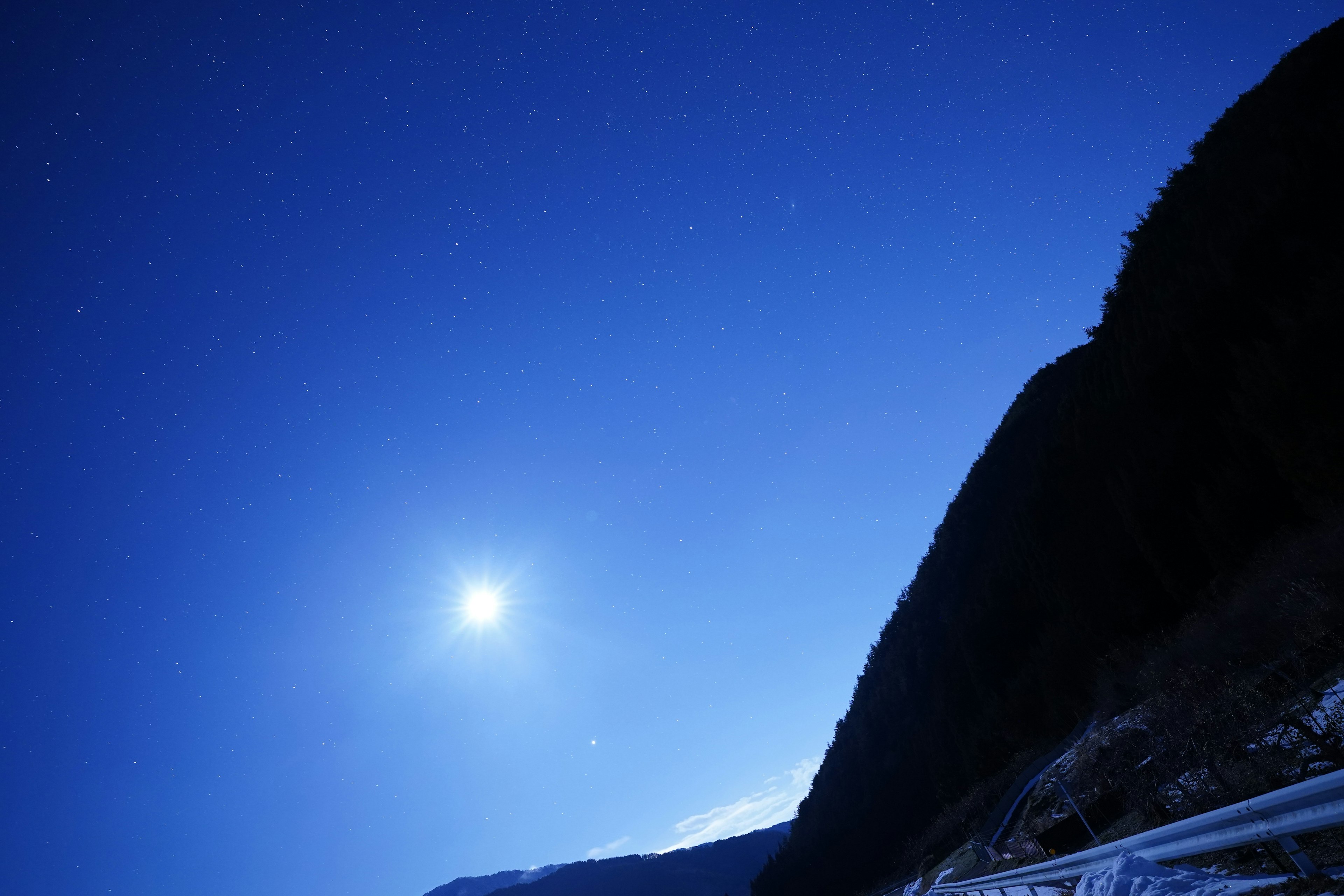 Pemandangan indah langit malam biru yang diterangi bintang dan bulan