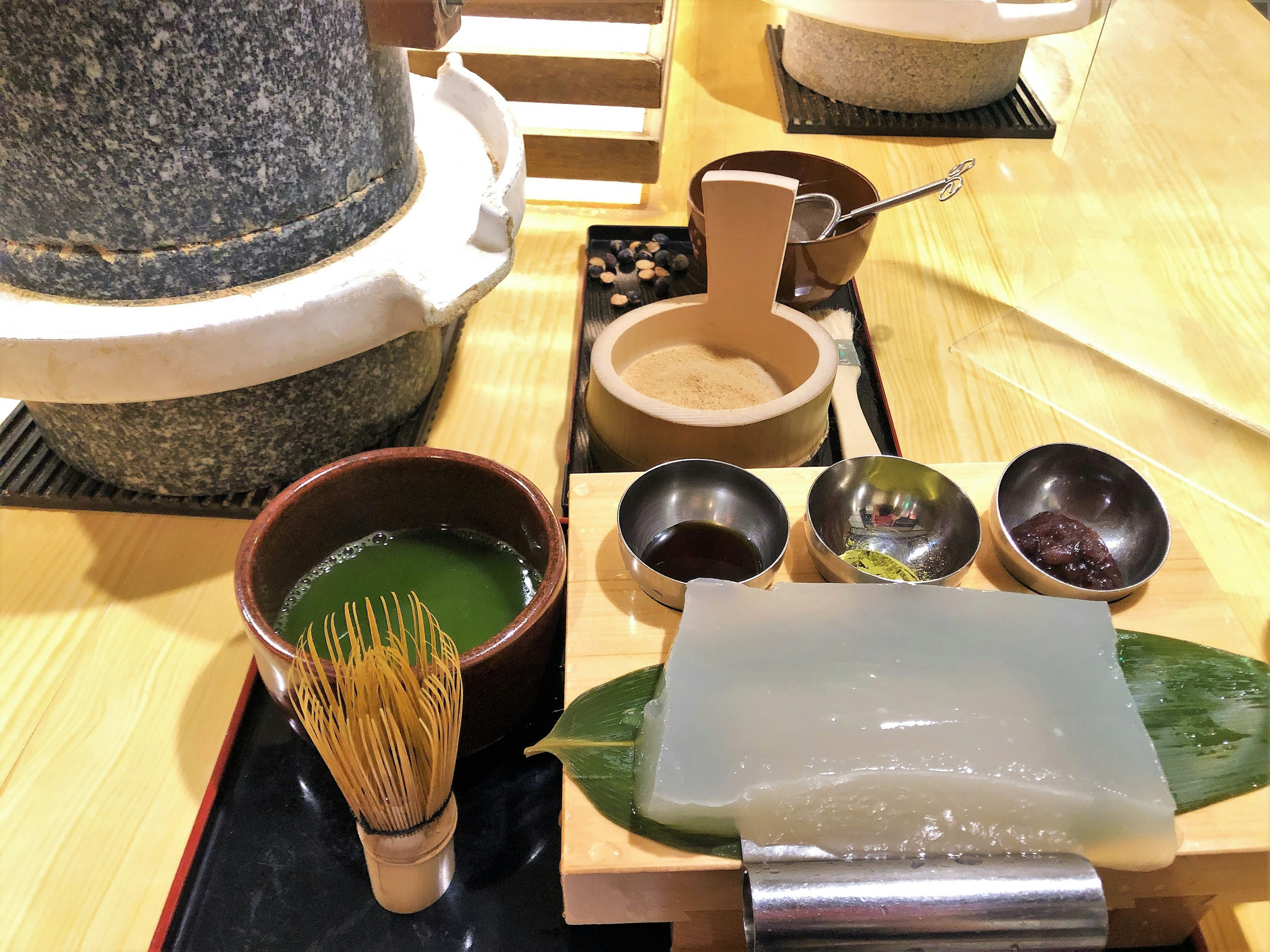 A display of traditional tea utensils and matcha on a table