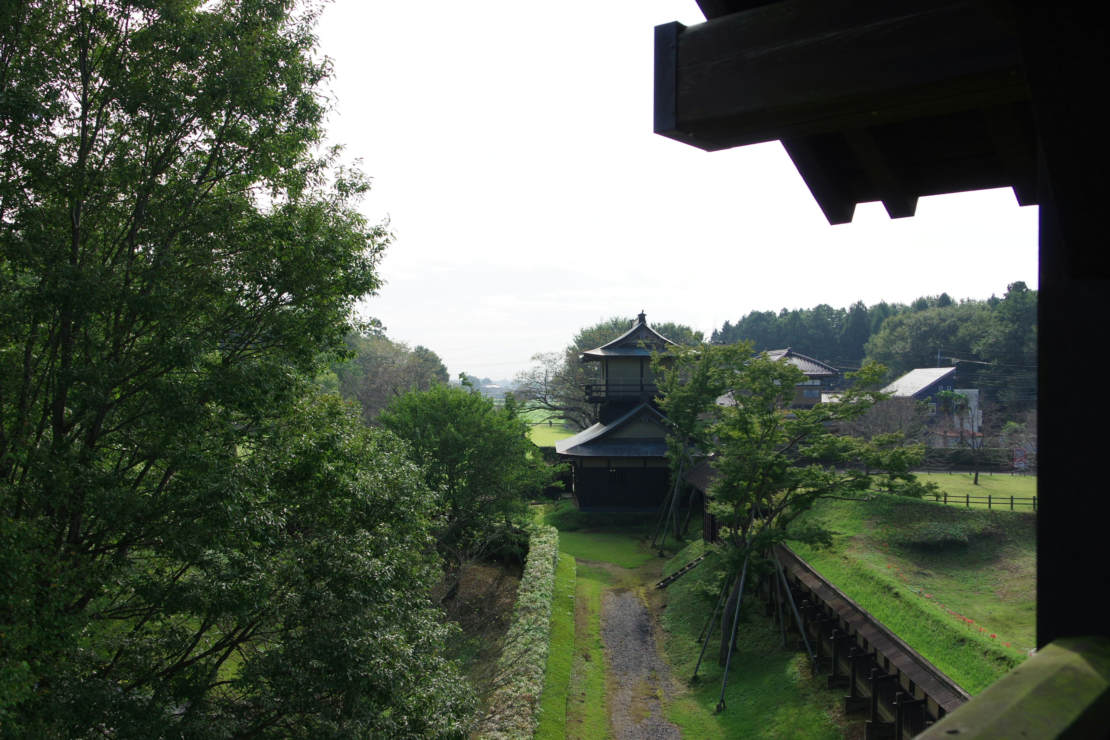 Traditionelles japanisches Gebäude umgeben von Grün und einem Weg