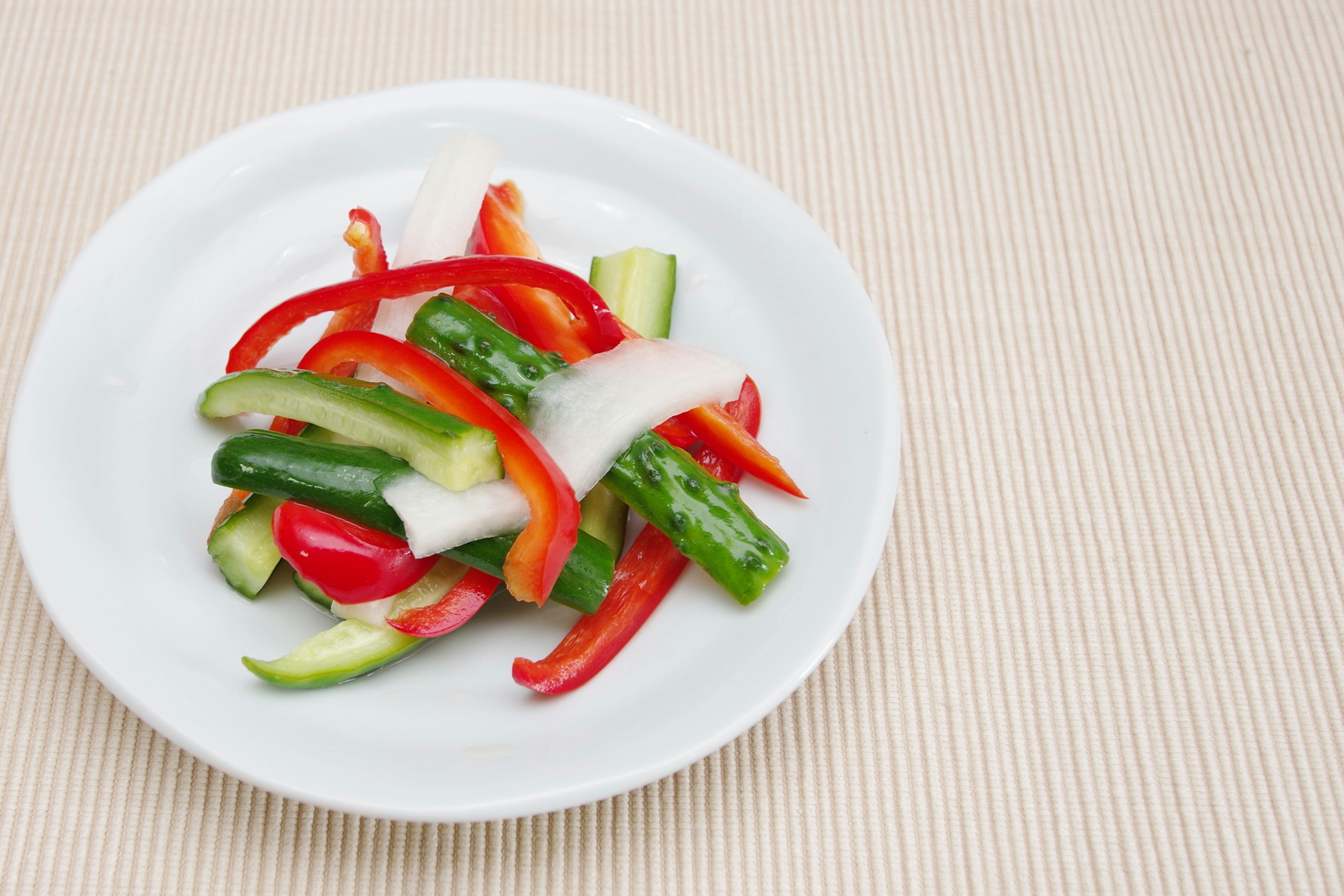 Salad paprika merah dan hijau serta bawang di piring putih