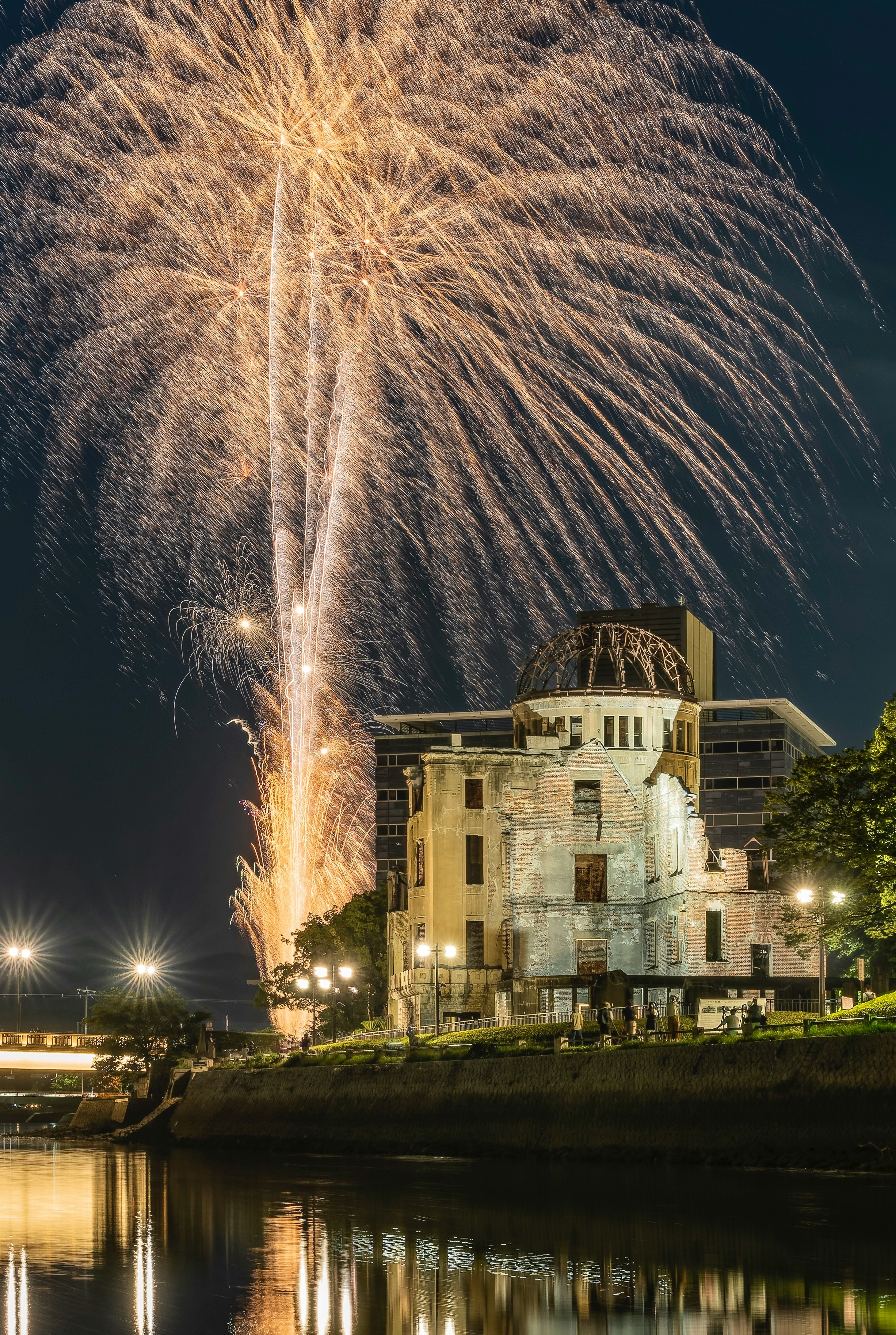Night view of Hiroshima's Atomic Bomb Dome with fireworks in the background