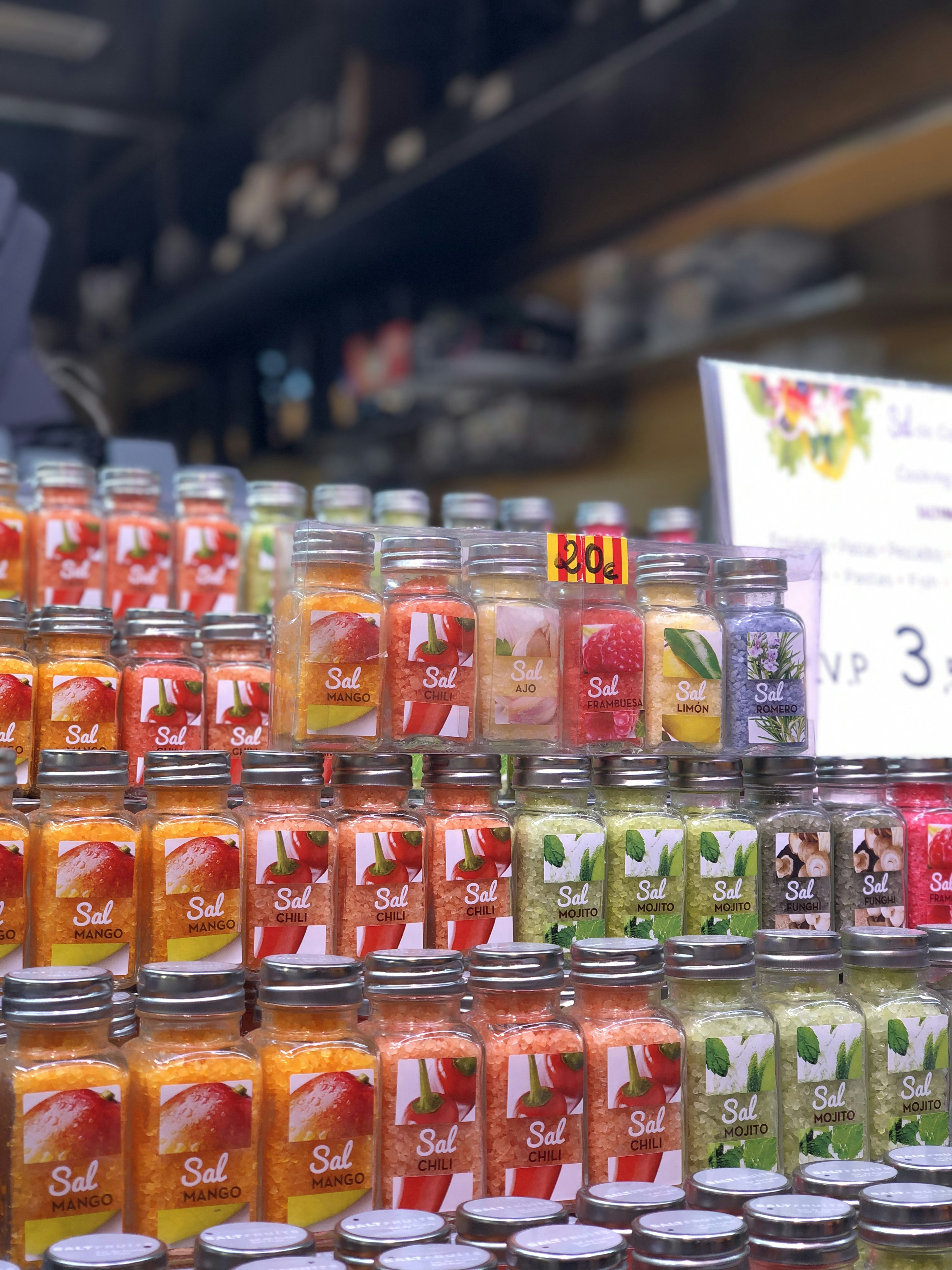 Des bocaux colorés de confitures de fruits disposés dans une vitrine de magasin