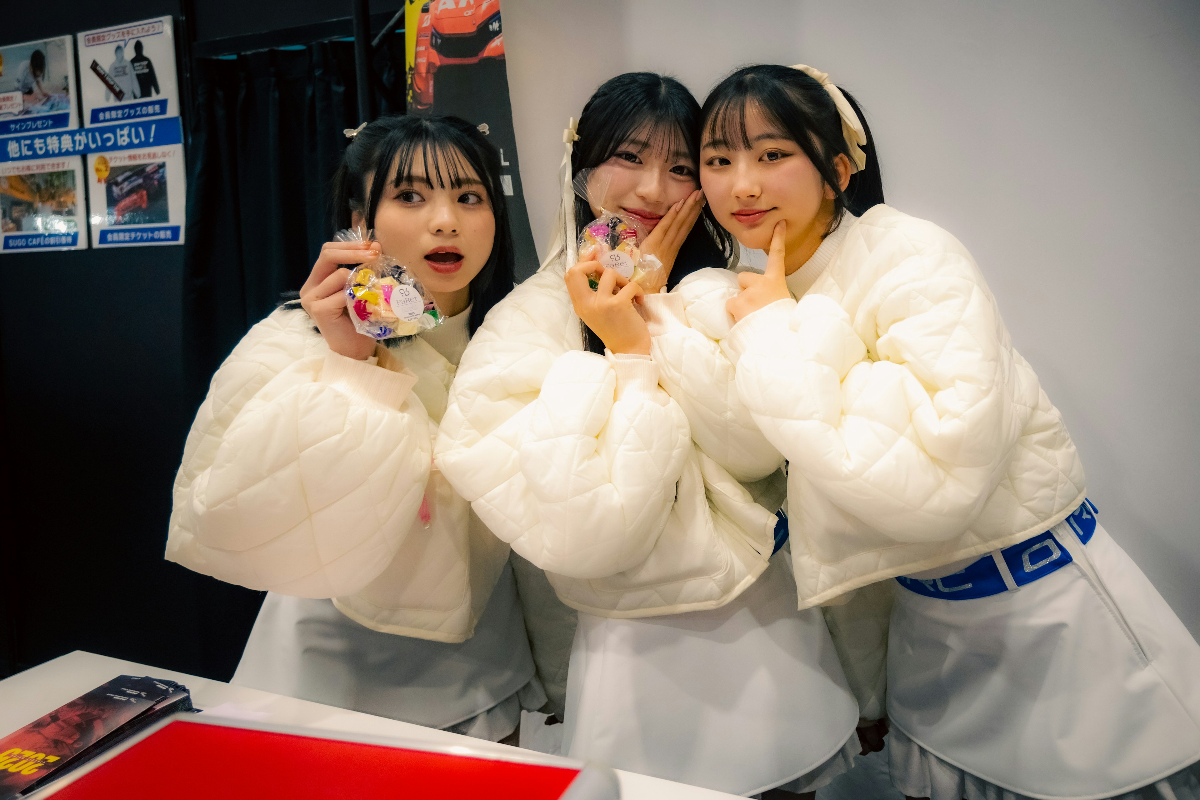 Trois femmes posant dans des vestes blanches avec des expressions joyeuses