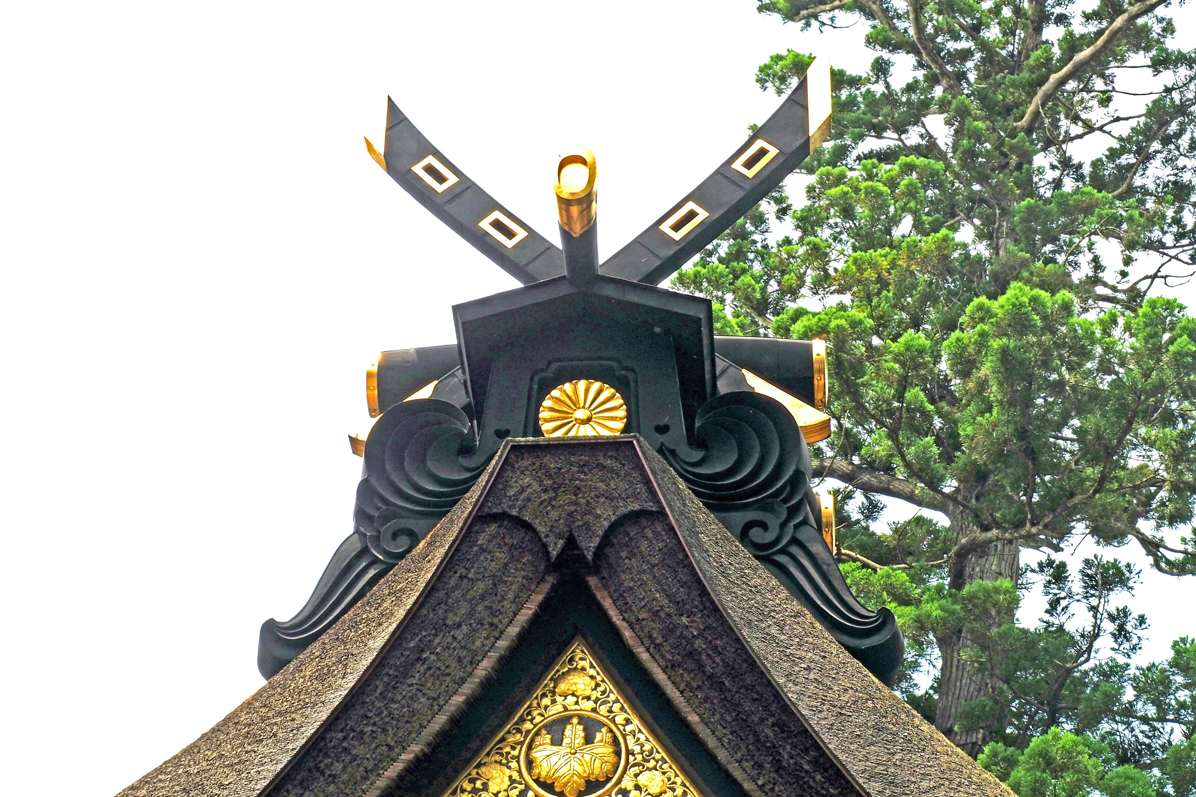 Dekorative Schwerter und goldene Details auf dem Dach eines traditionellen japanischen Gebäudes