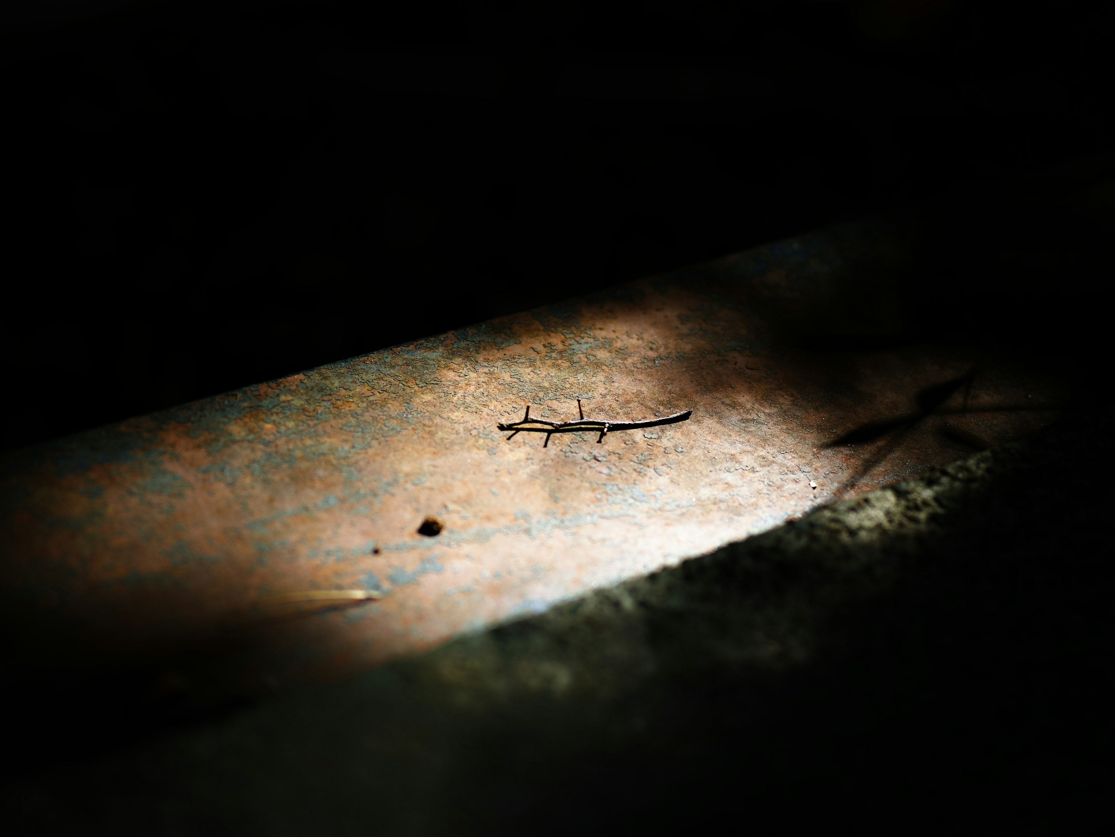 Contrast of light and shadow on a metallic surface in a dark background