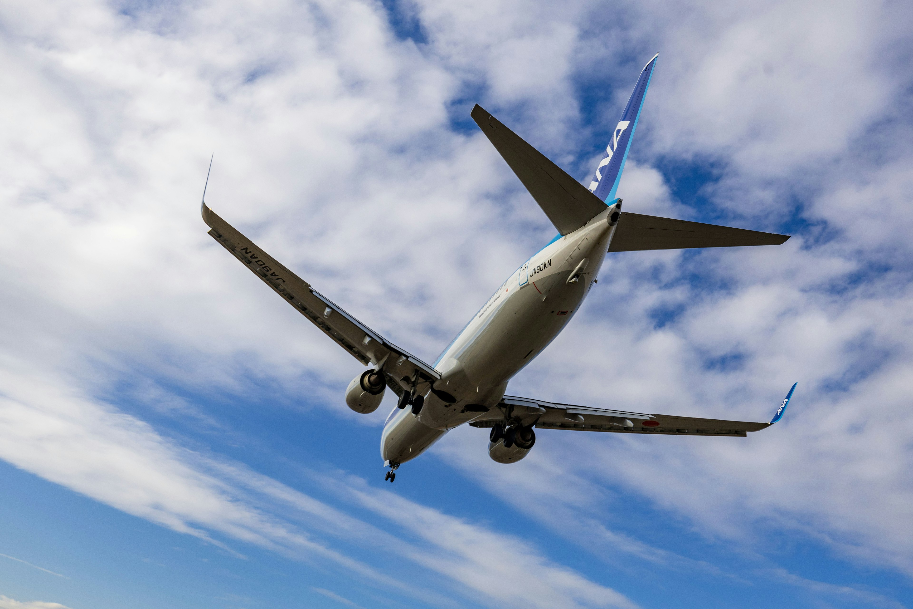 Airplane flying under a clear sky from a low angle perspective