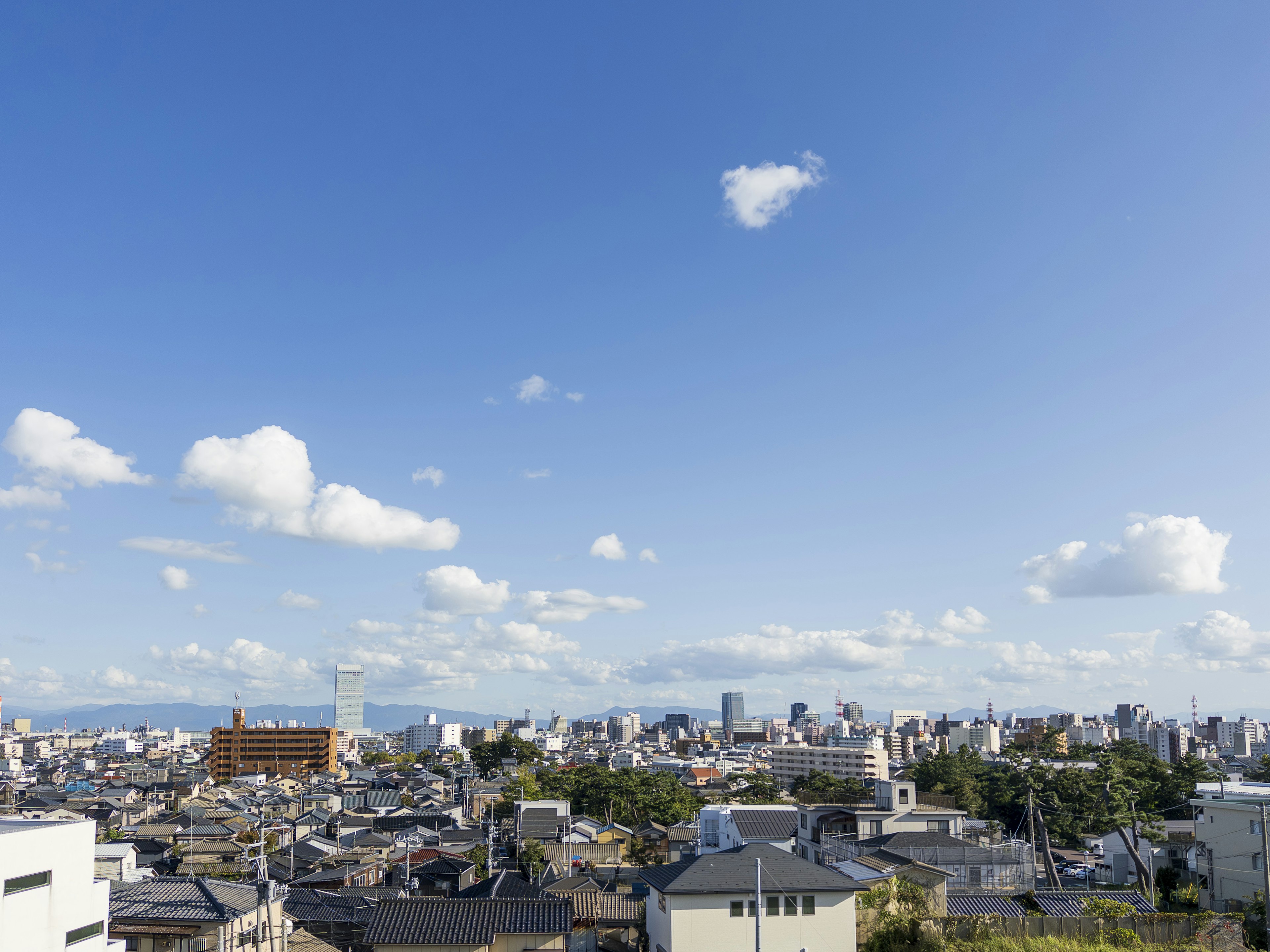 Paesaggio urbano sotto un cielo blu con un mix di edifici tradizionali e moderni