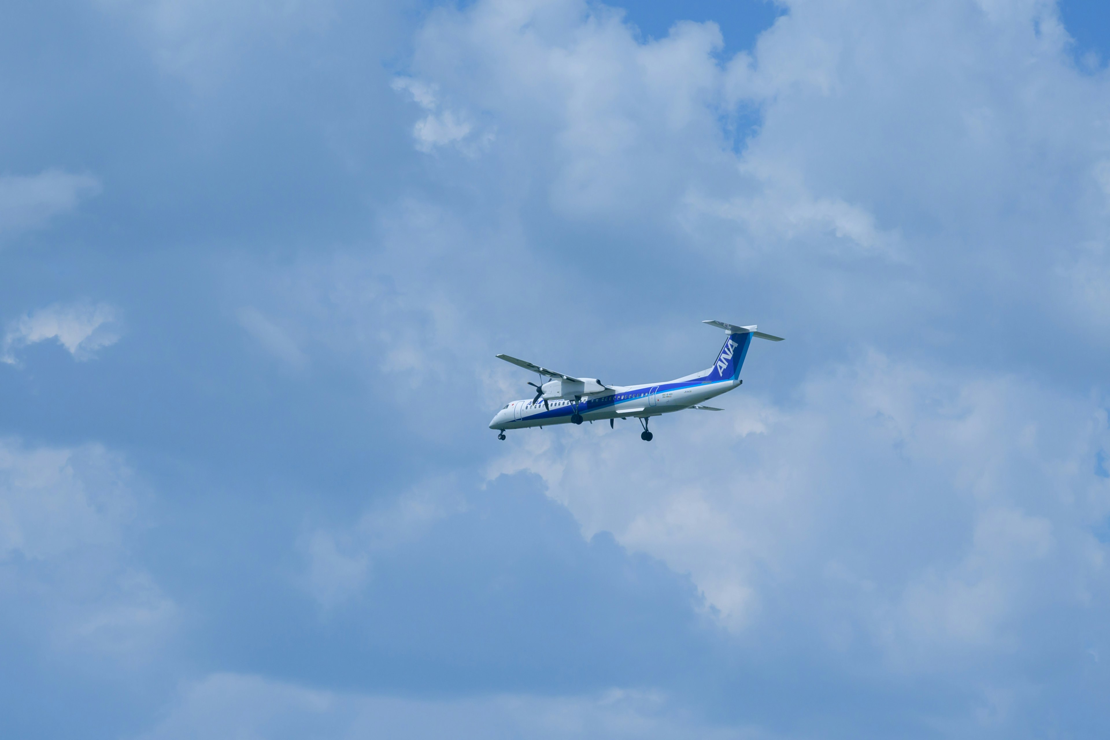 青空に飛行する小型のプロペラ機