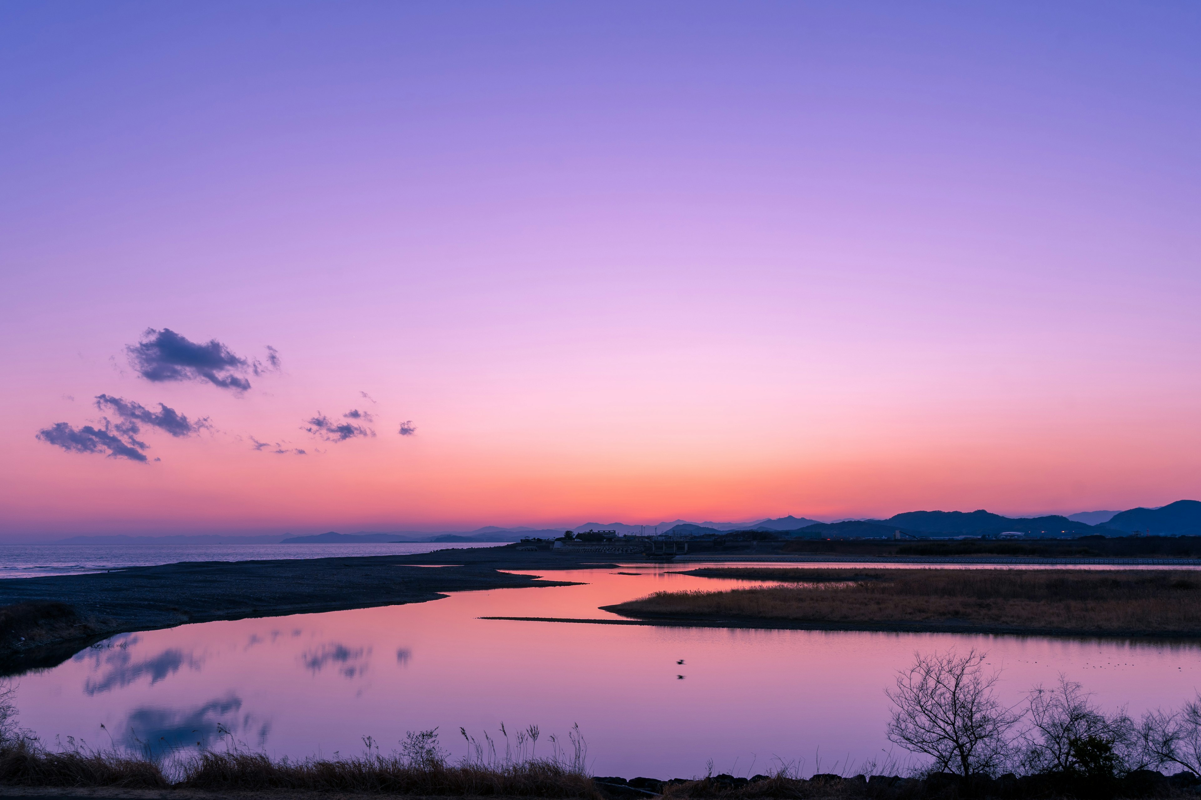 美しい紫色の夕焼けと穏やかな水面が映る風景