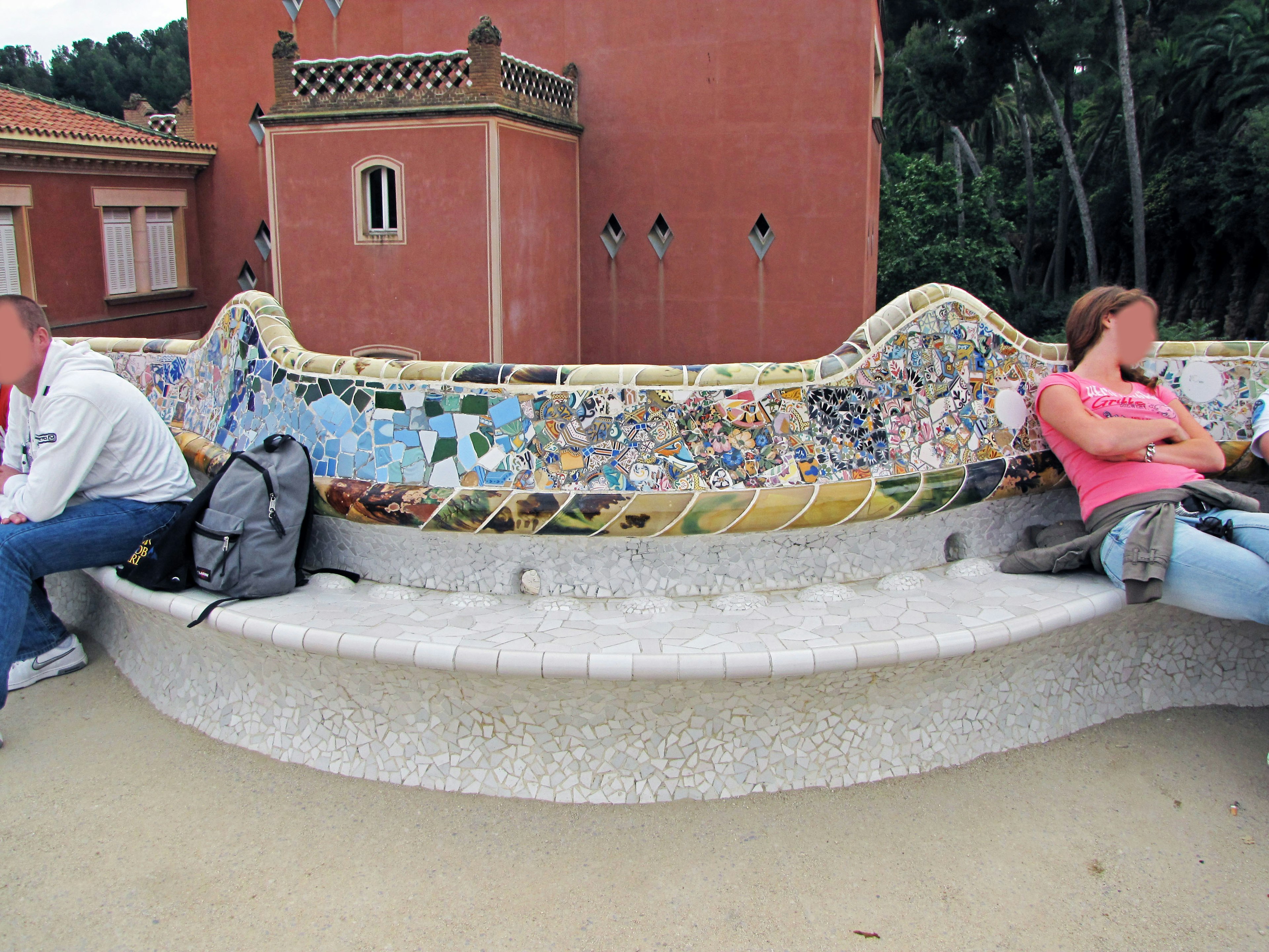 Escena de parque con un banco de mosaico y un edificio al fondo