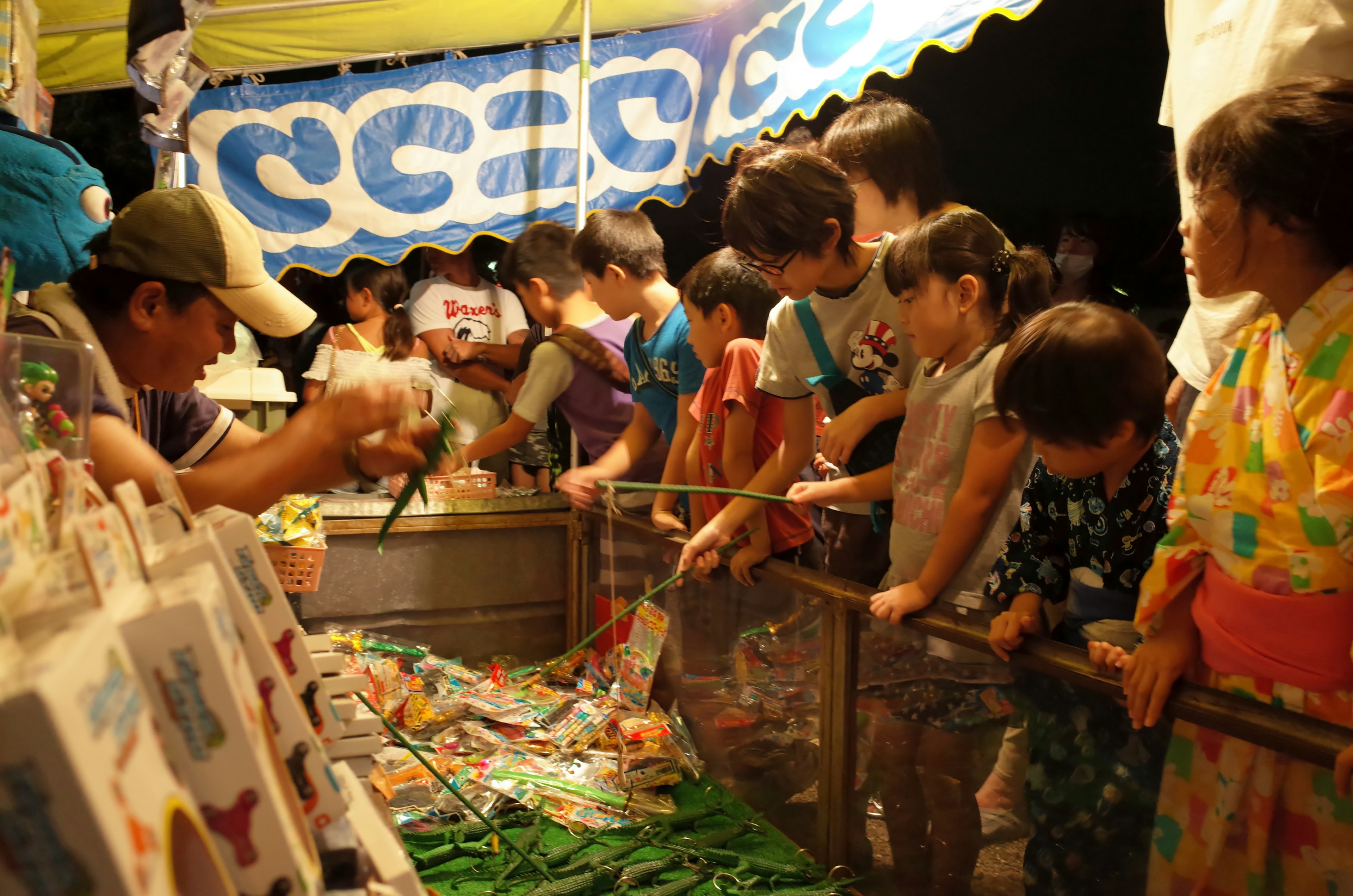 Niños disfrutando de un mercado nocturno con un puesto de comida