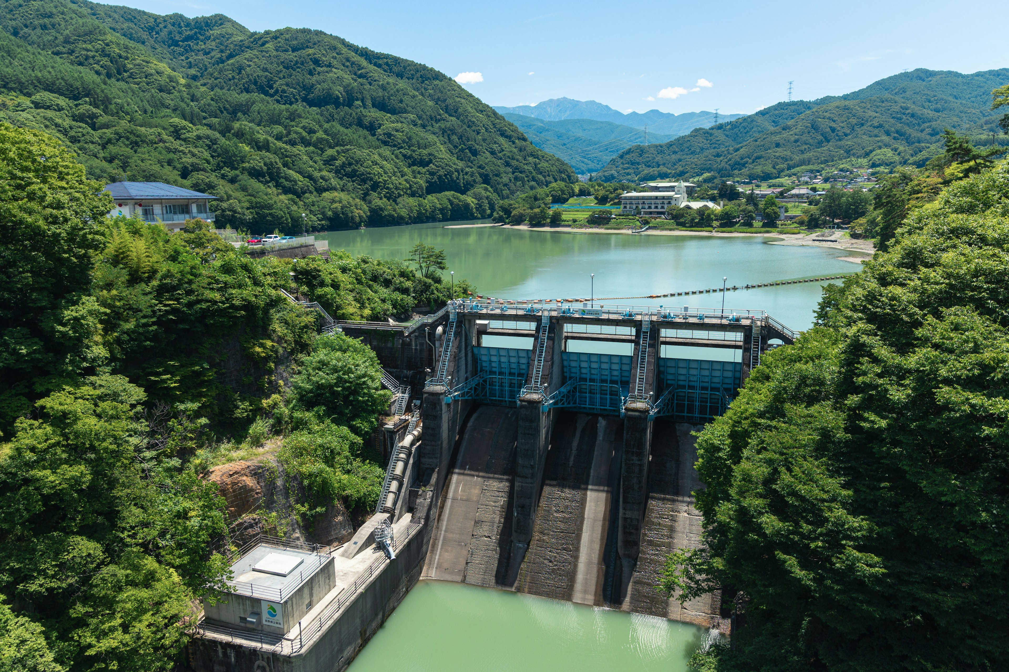 Vista panoramica di una diga circondata da vegetazione lussureggiante e un lago tranquillo