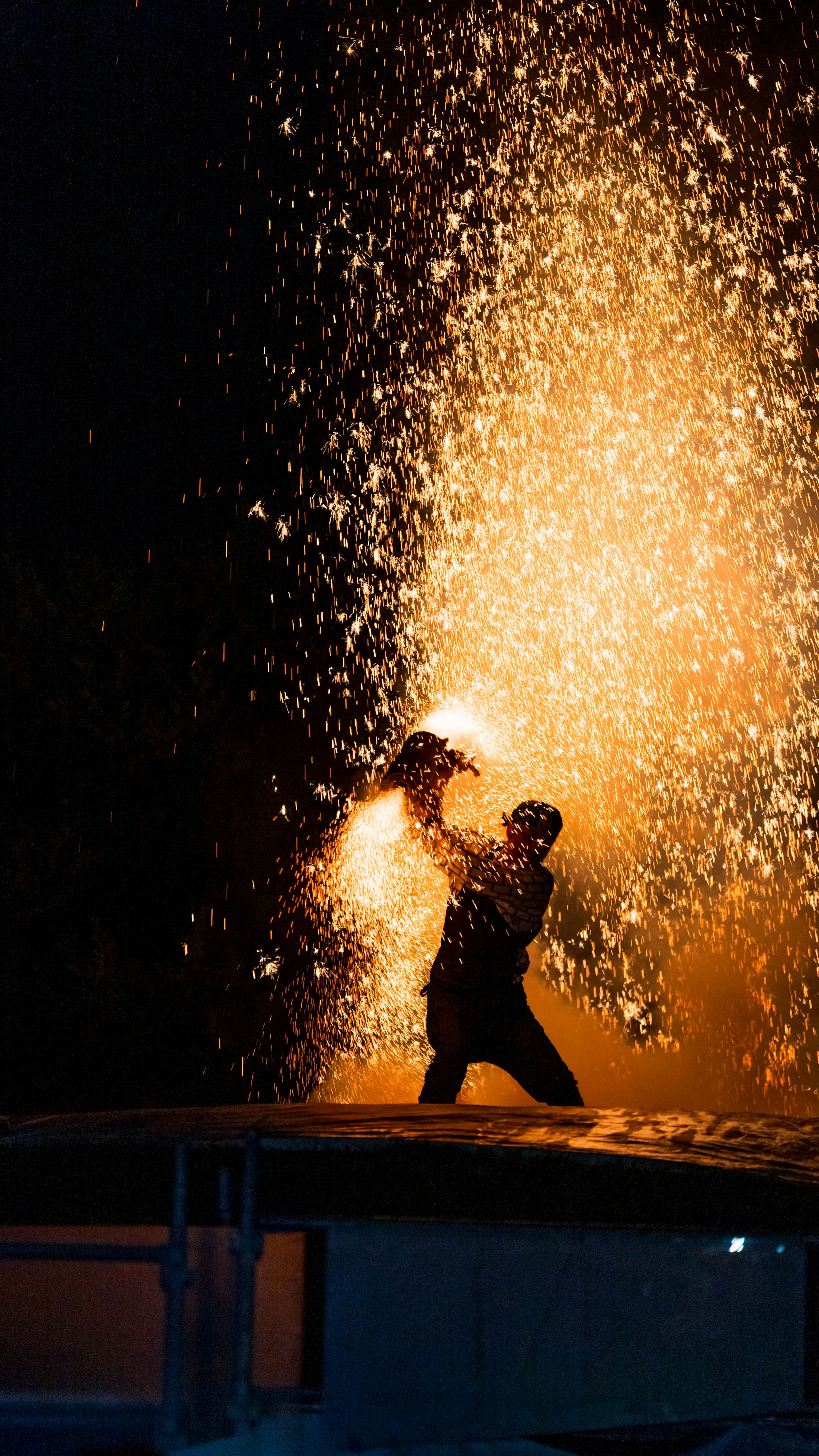 Silhouette of a worker creating sparks