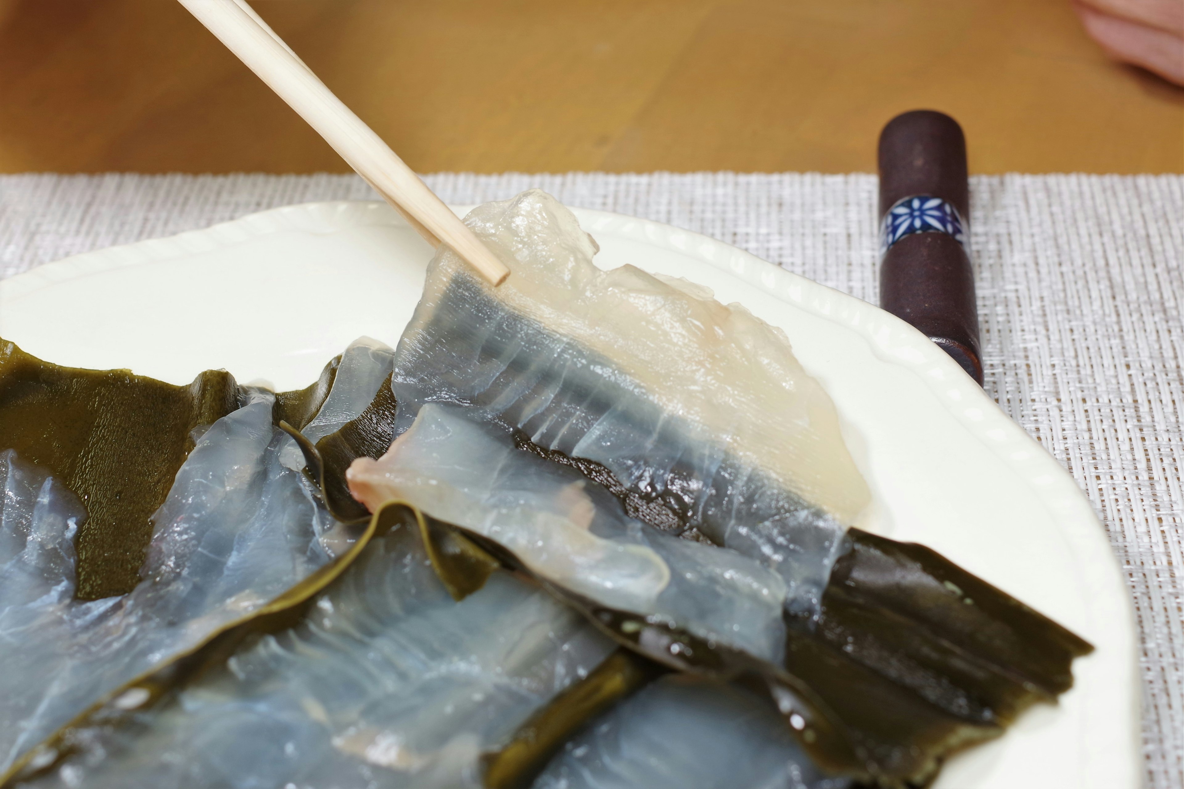 Plat de légumes marins avec des algues en train d'être prises avec des baguettes