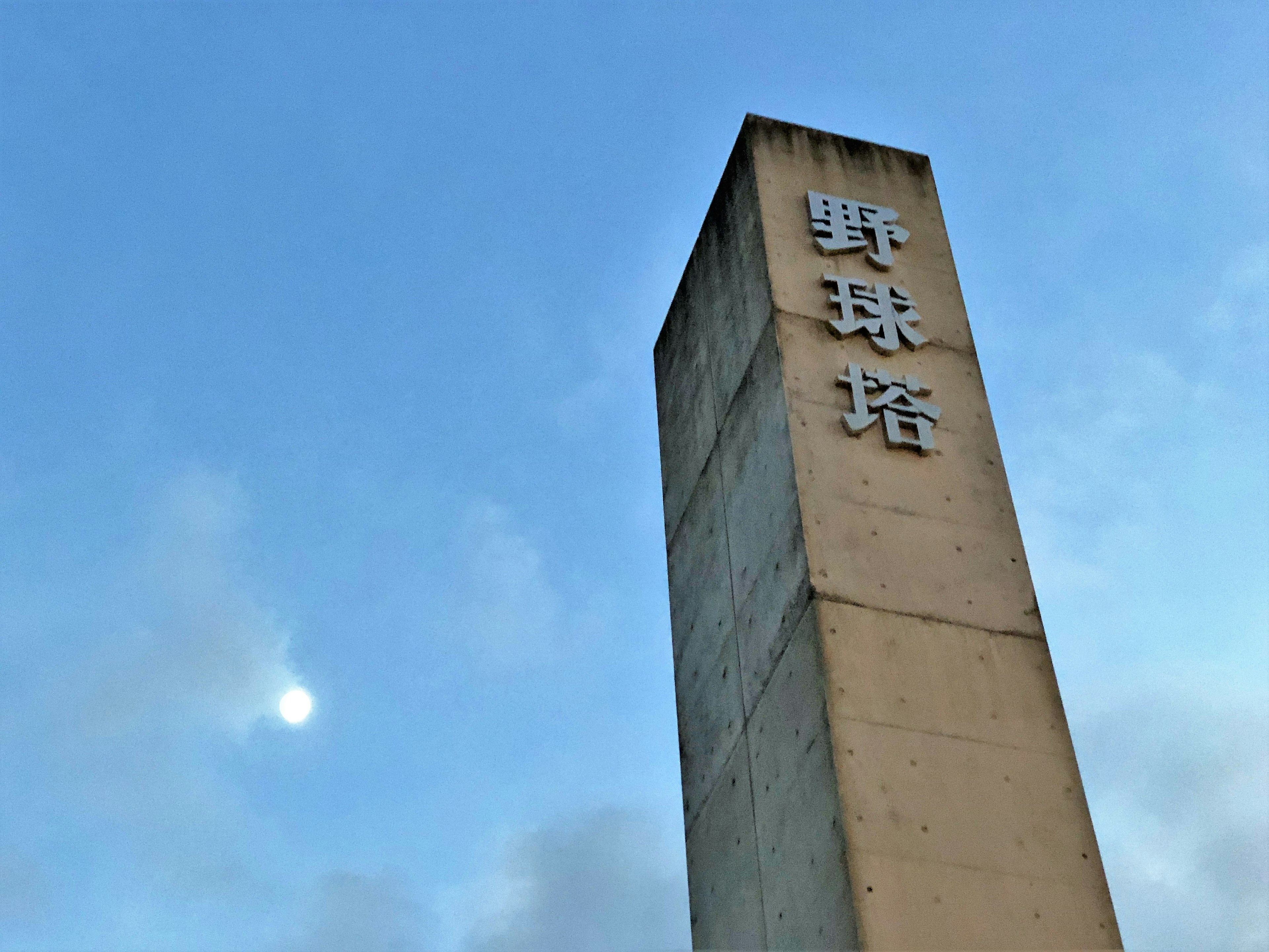 Menara beton tinggi dengan karakter Cina di bawah langit biru