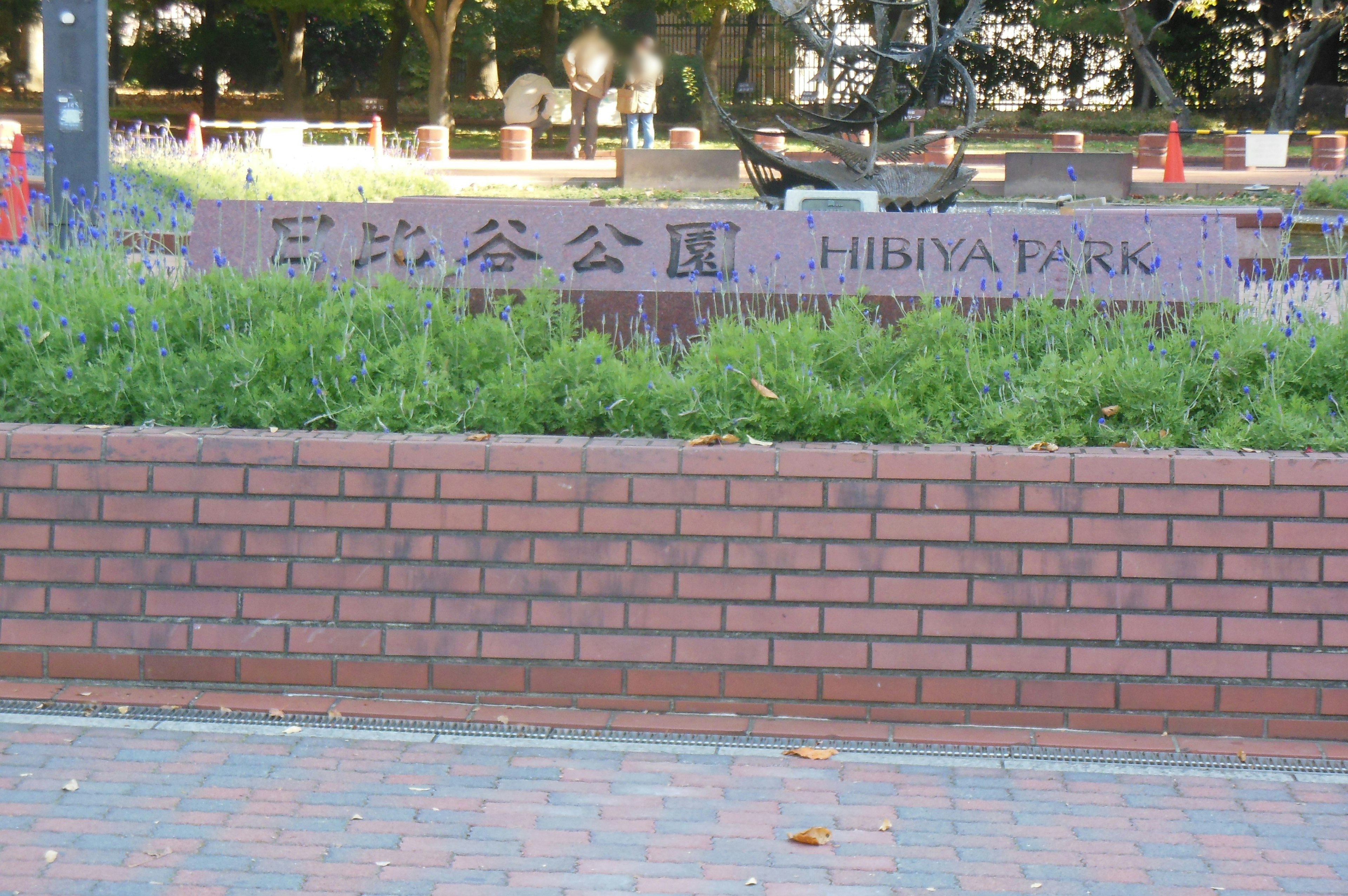 Steinmonument im Hibiya-Park umgeben von üppigem Grün