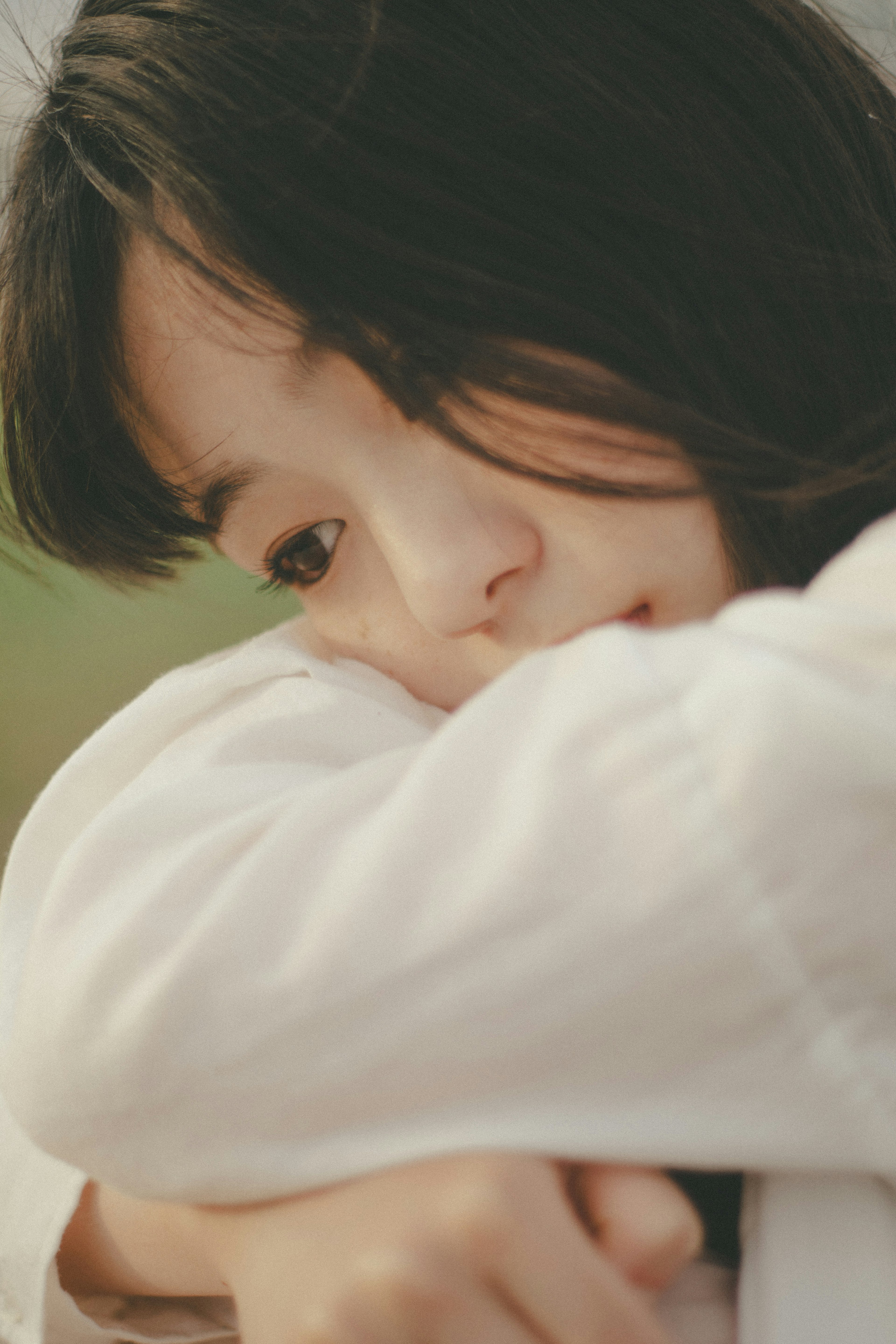 Close-up of a young woman wearing a white shirt with a serene expression