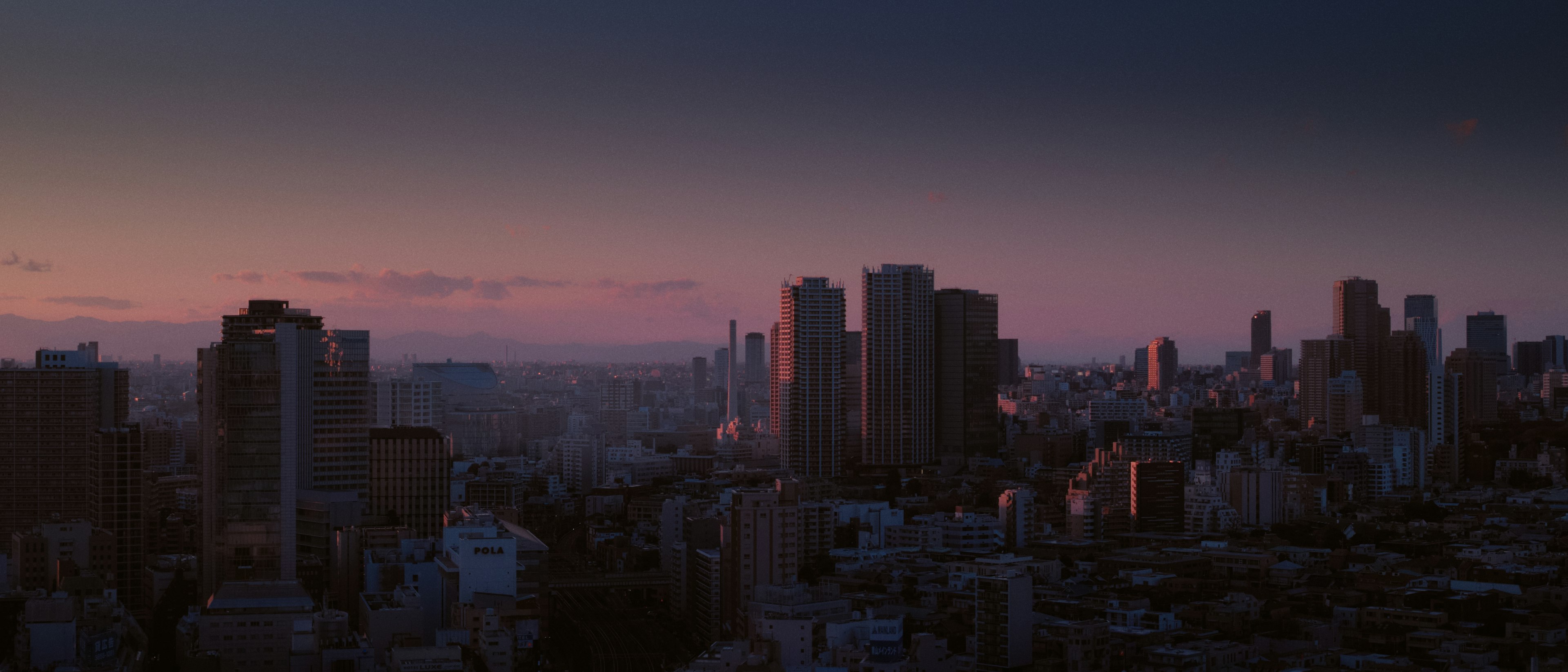 Vue panoramique d'une ville au crépuscule avec des gratte-ciel et un ciel dégradé