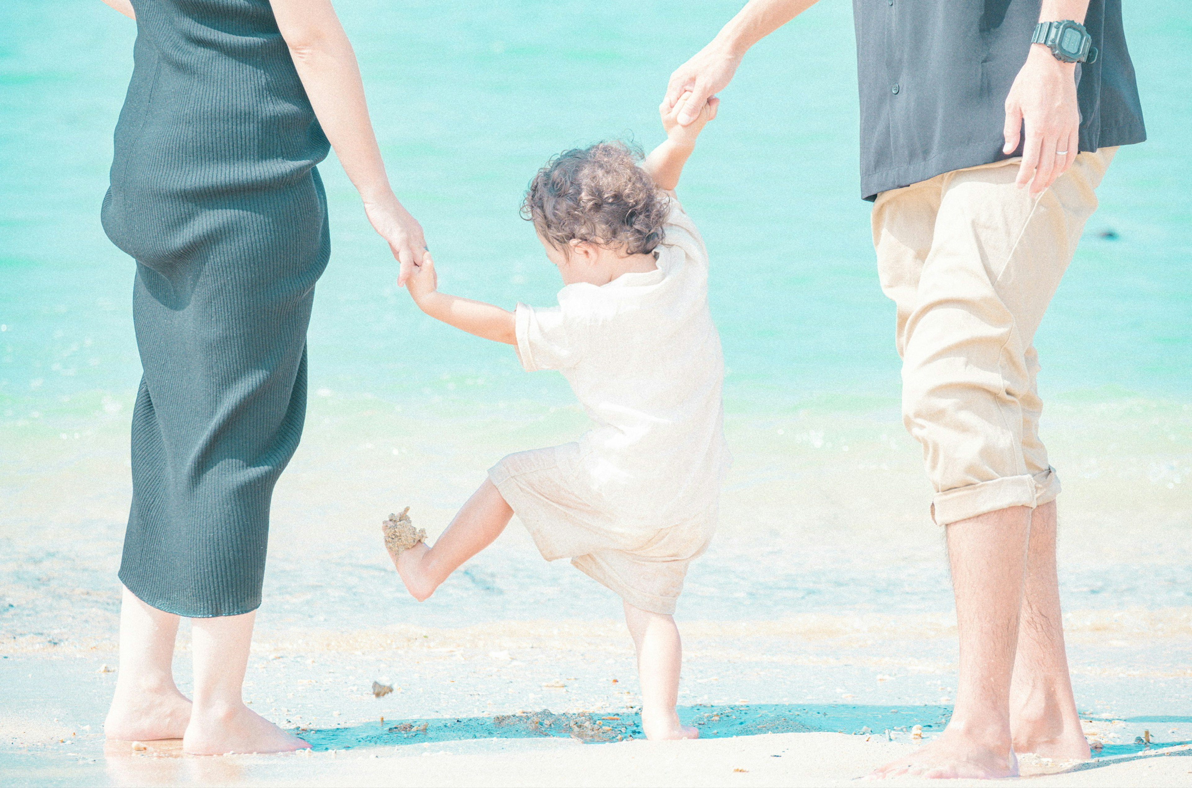 Keluarga menikmati waktu di pantai anak bermain di air