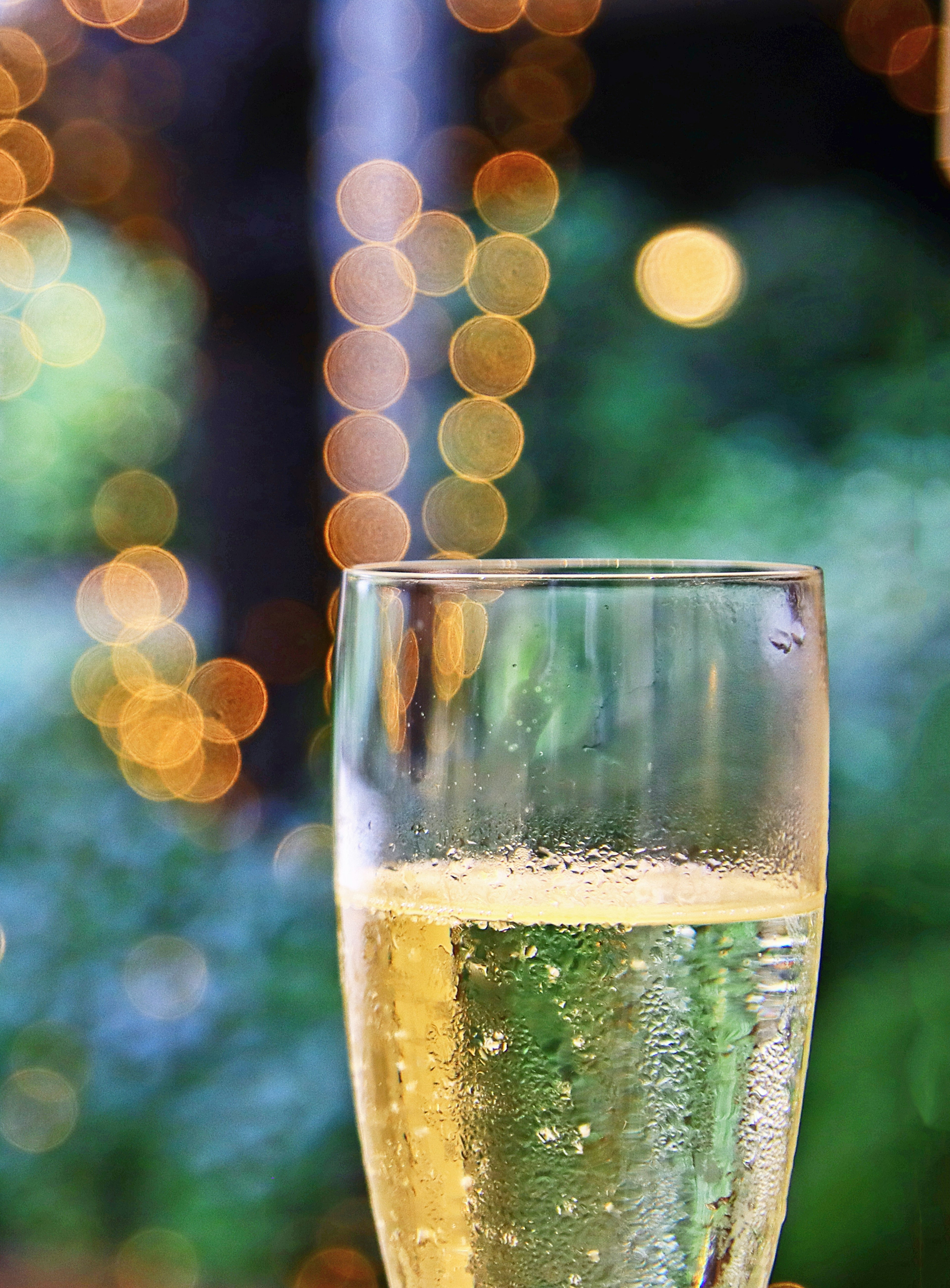 Transparente Champagnerglas mit unscharfen Bokehlichtern im Hintergrund