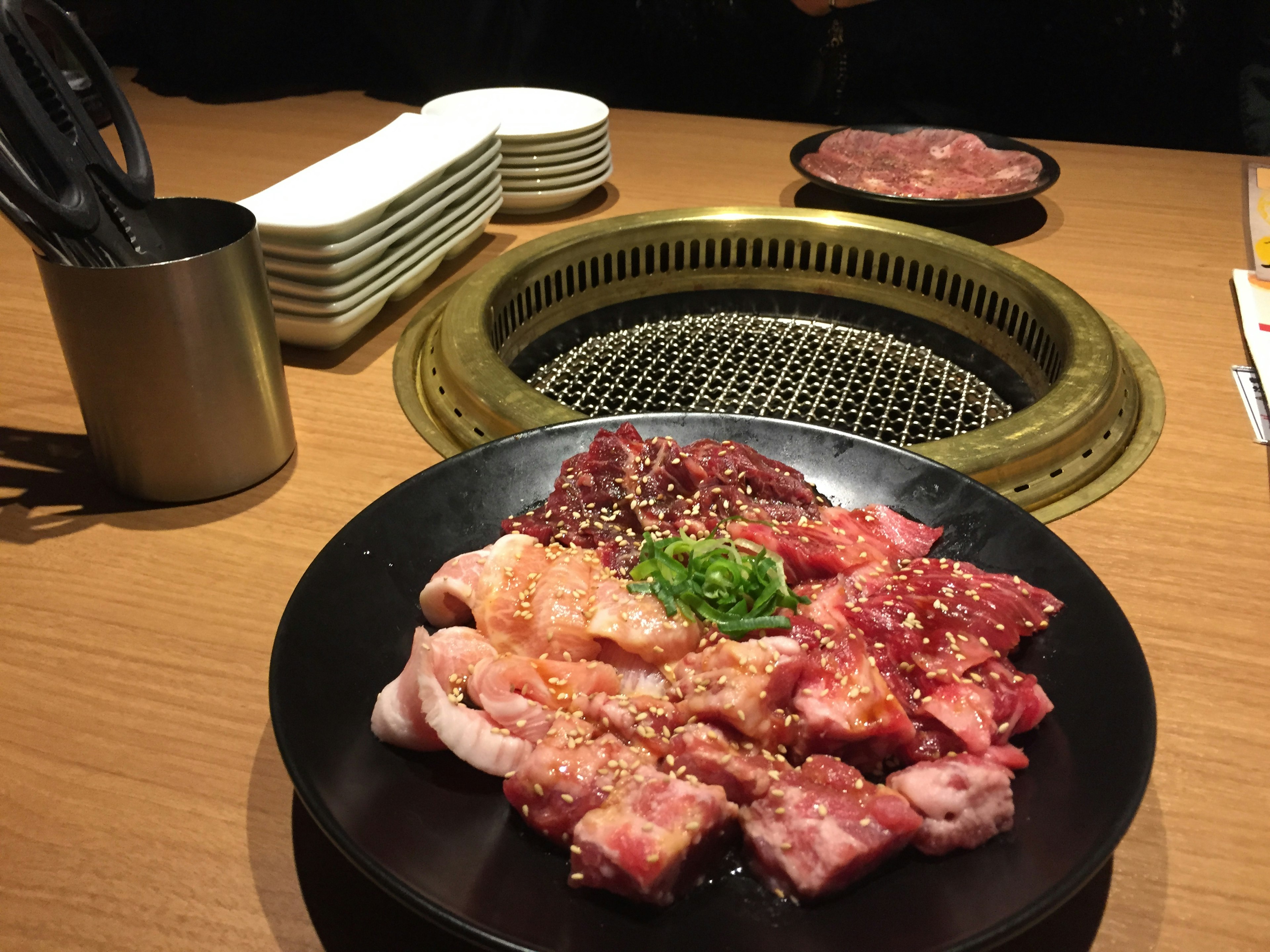 Plate of assorted grilled meats with a grill in the background