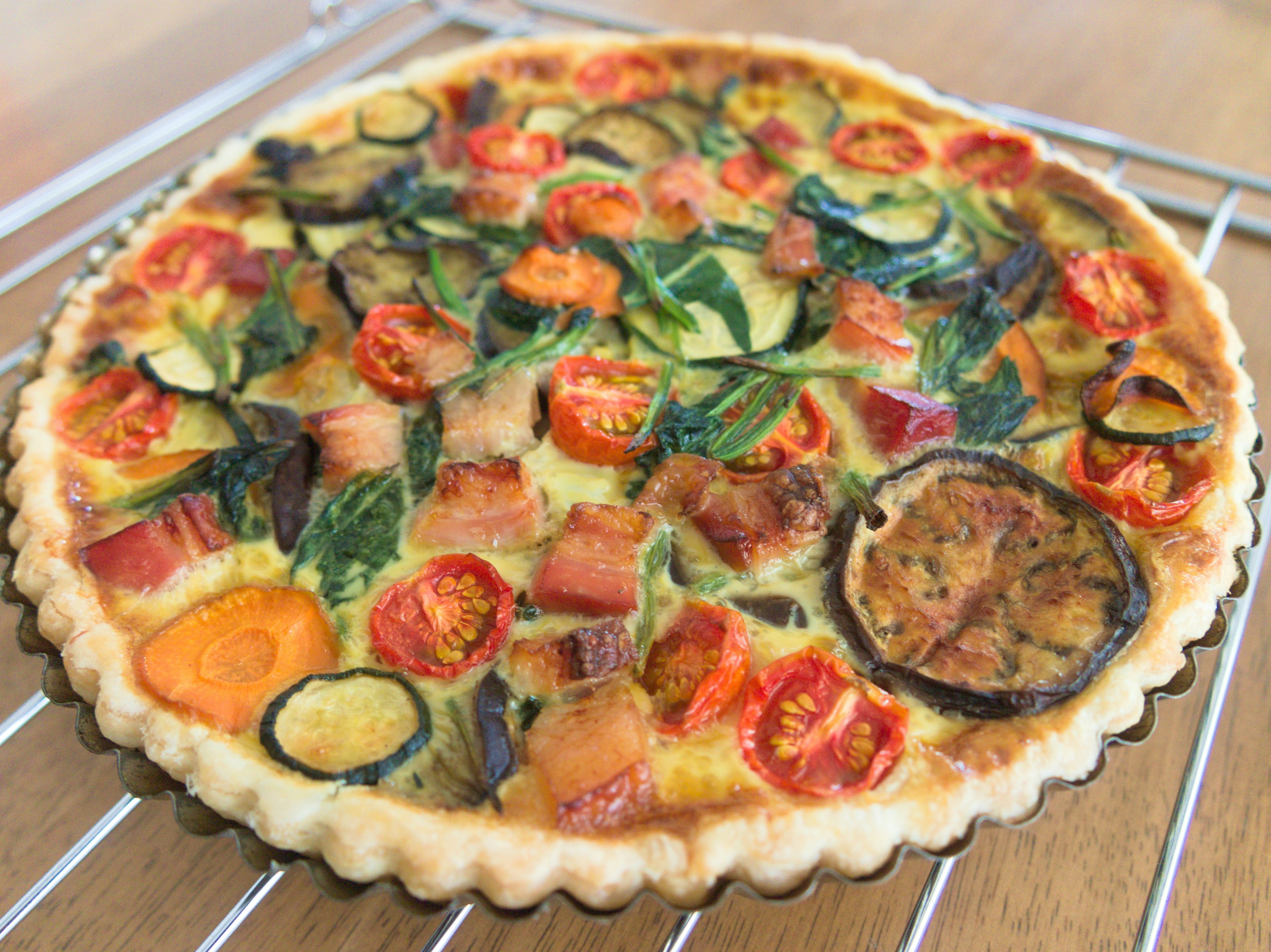 Torta salata con verdure colorate come pomodori e zucchine