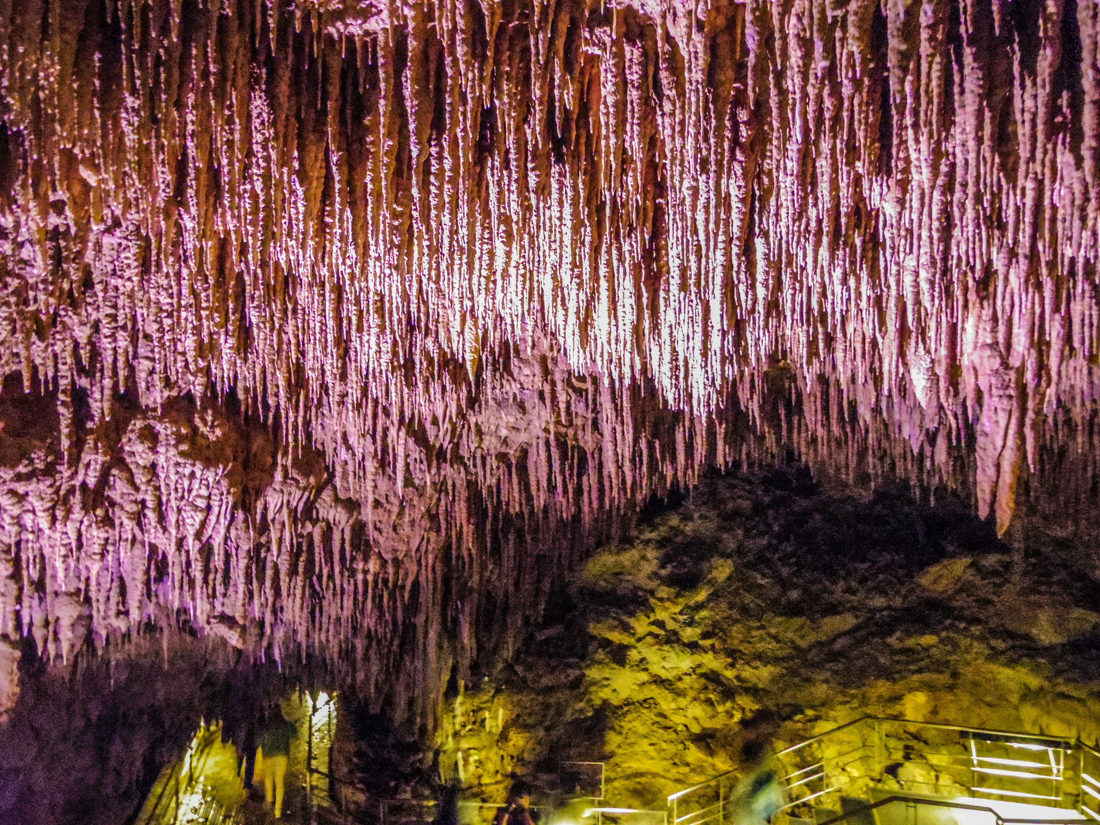 Uniche stalattiti viola appese al soffitto della grotta