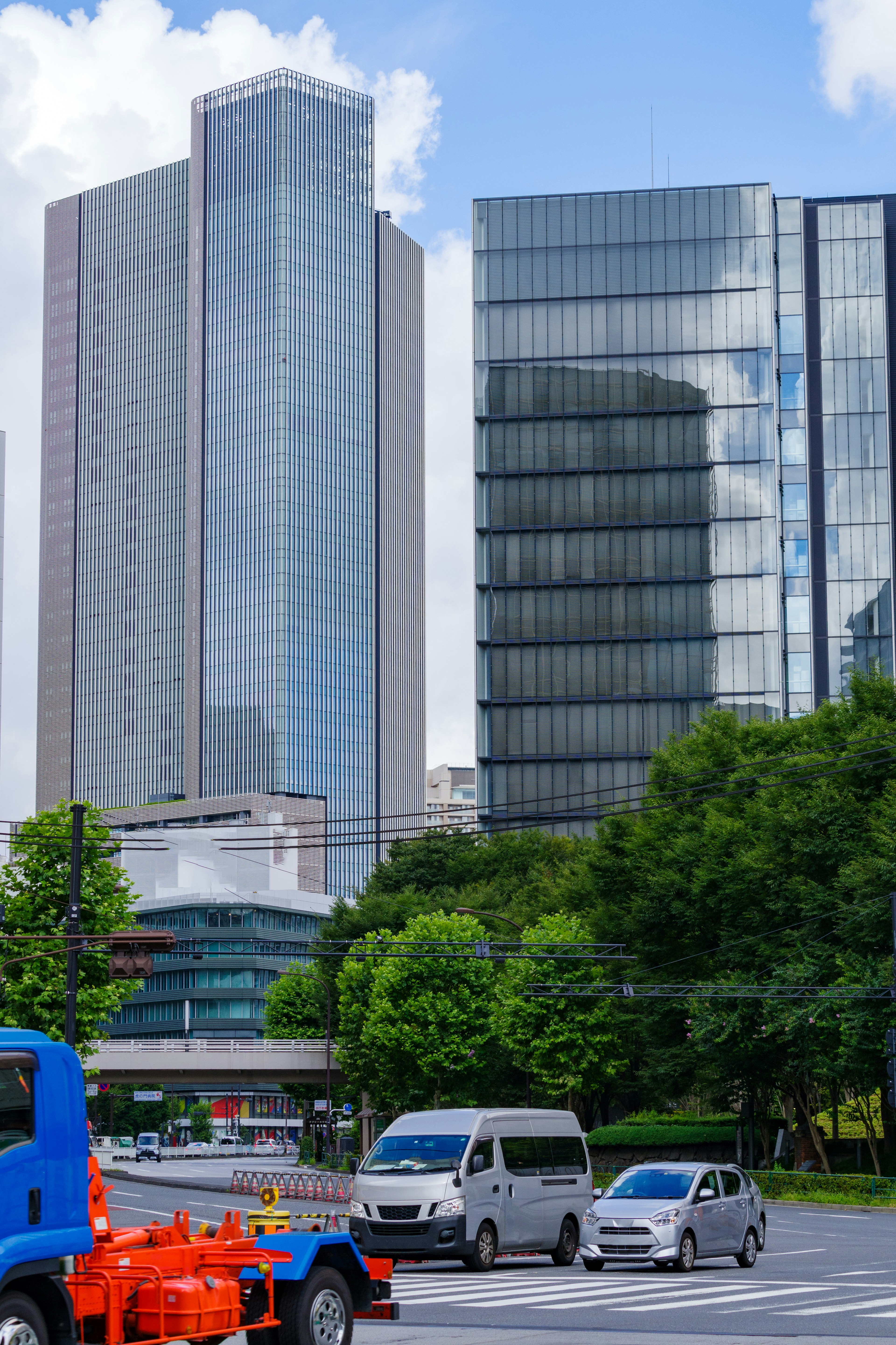 Stadtlandschaft mit Wolkenkratzern und moderner Architektur Fahrzeuge auf der Straße und üppiges Grün