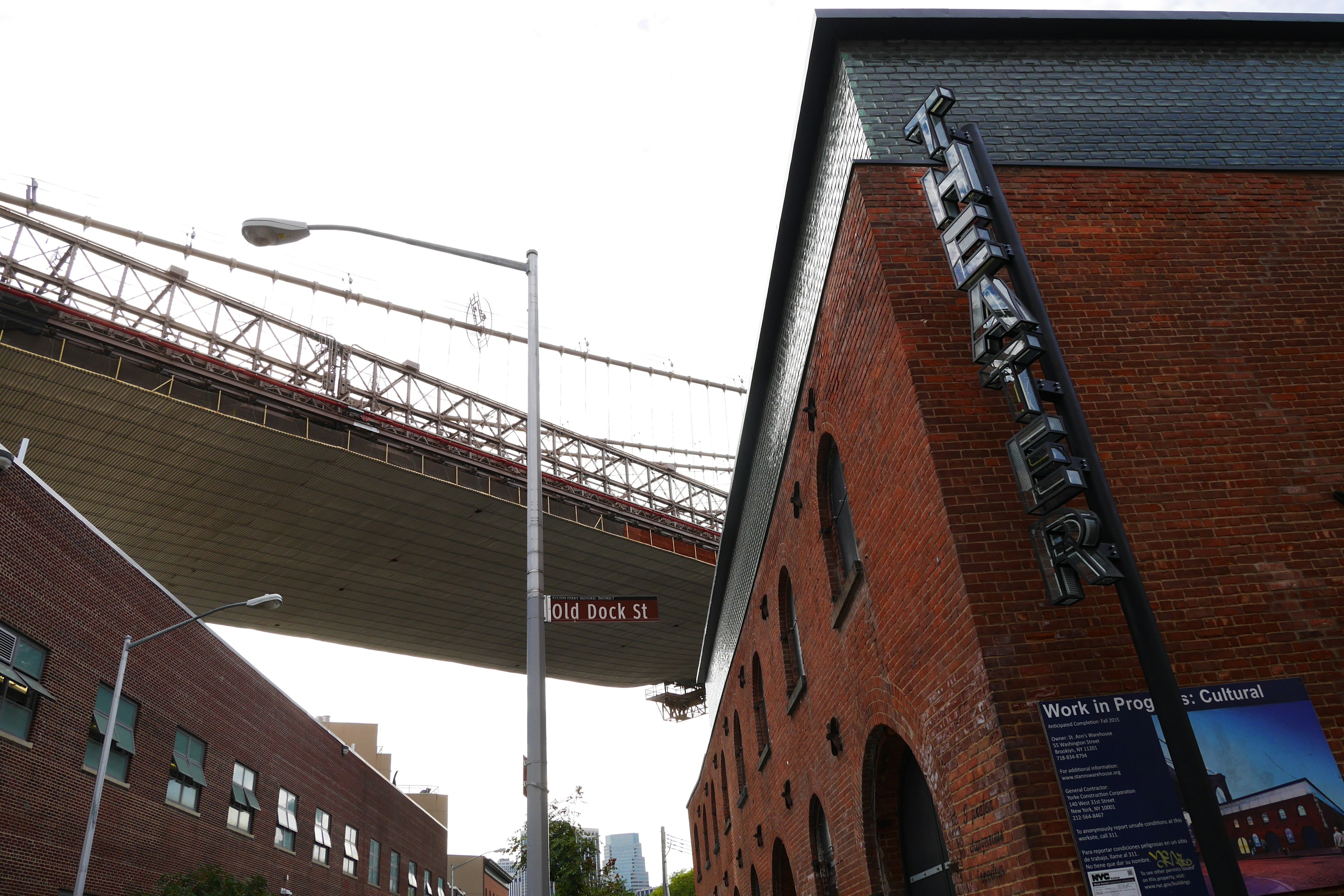 Bâtiment de théâtre en briques rouges avec un pont au-dessus